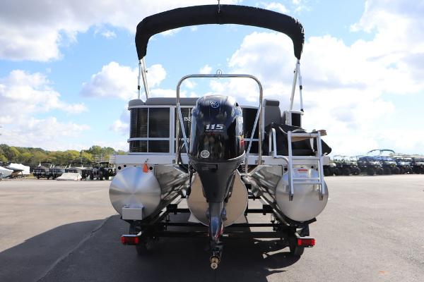 2024 Bennington 20 SL pontoon boat with outboard motor, parked outdoors.