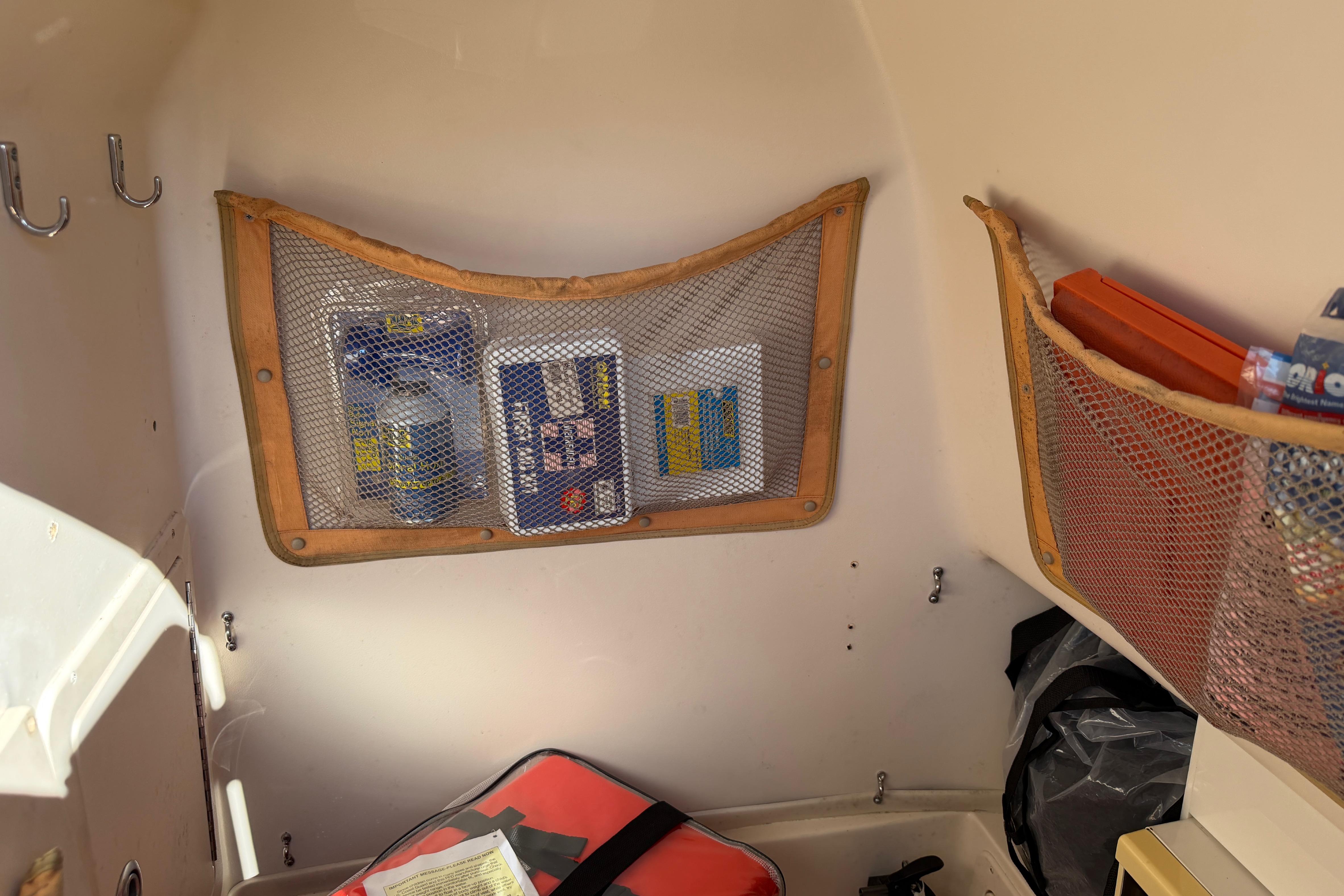 Interior storage of 2004 Grady White 273 boat with mesh pockets and supplies.