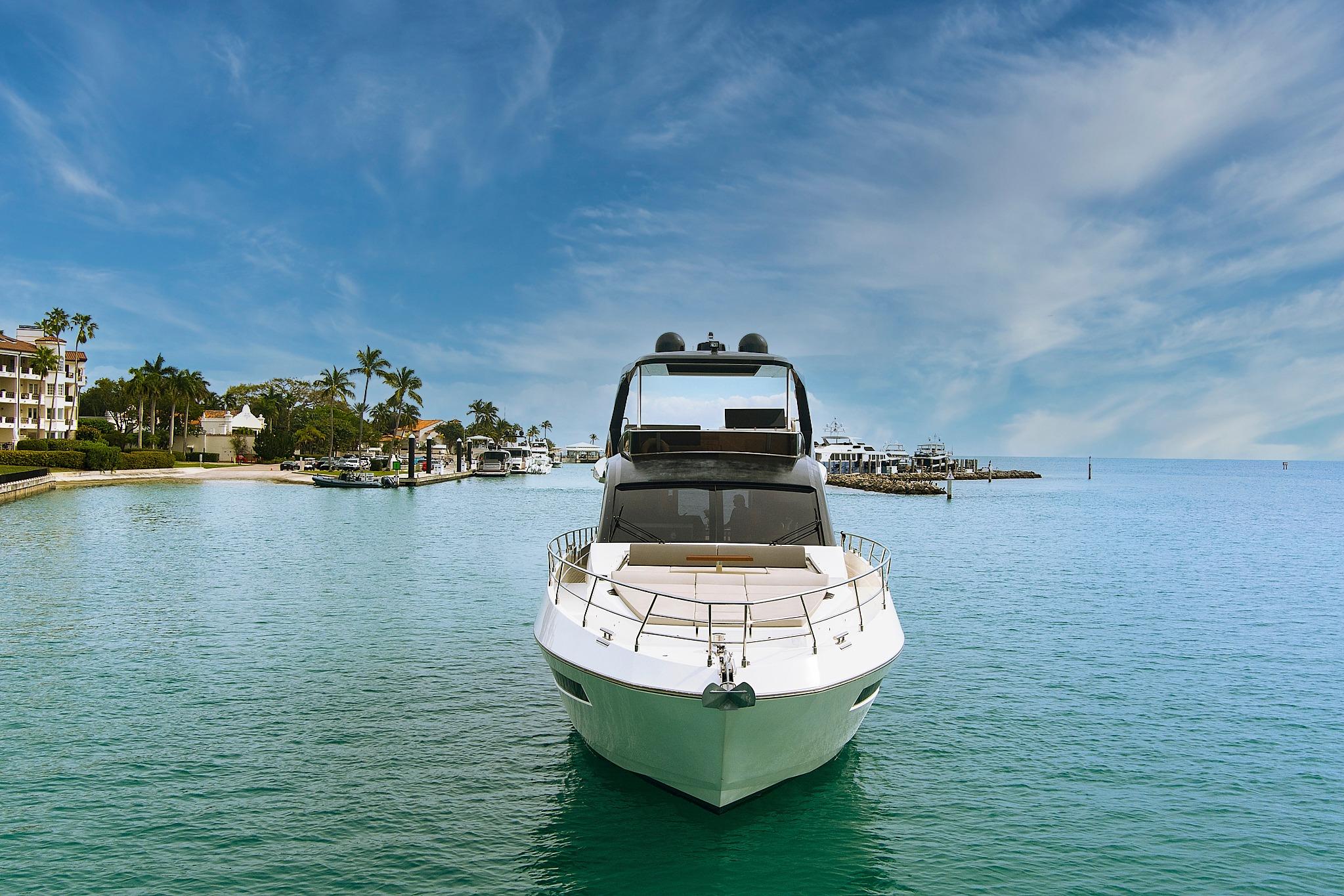 2022 Astondoa 66 Flybridge yacht docked in a serene marina setting.