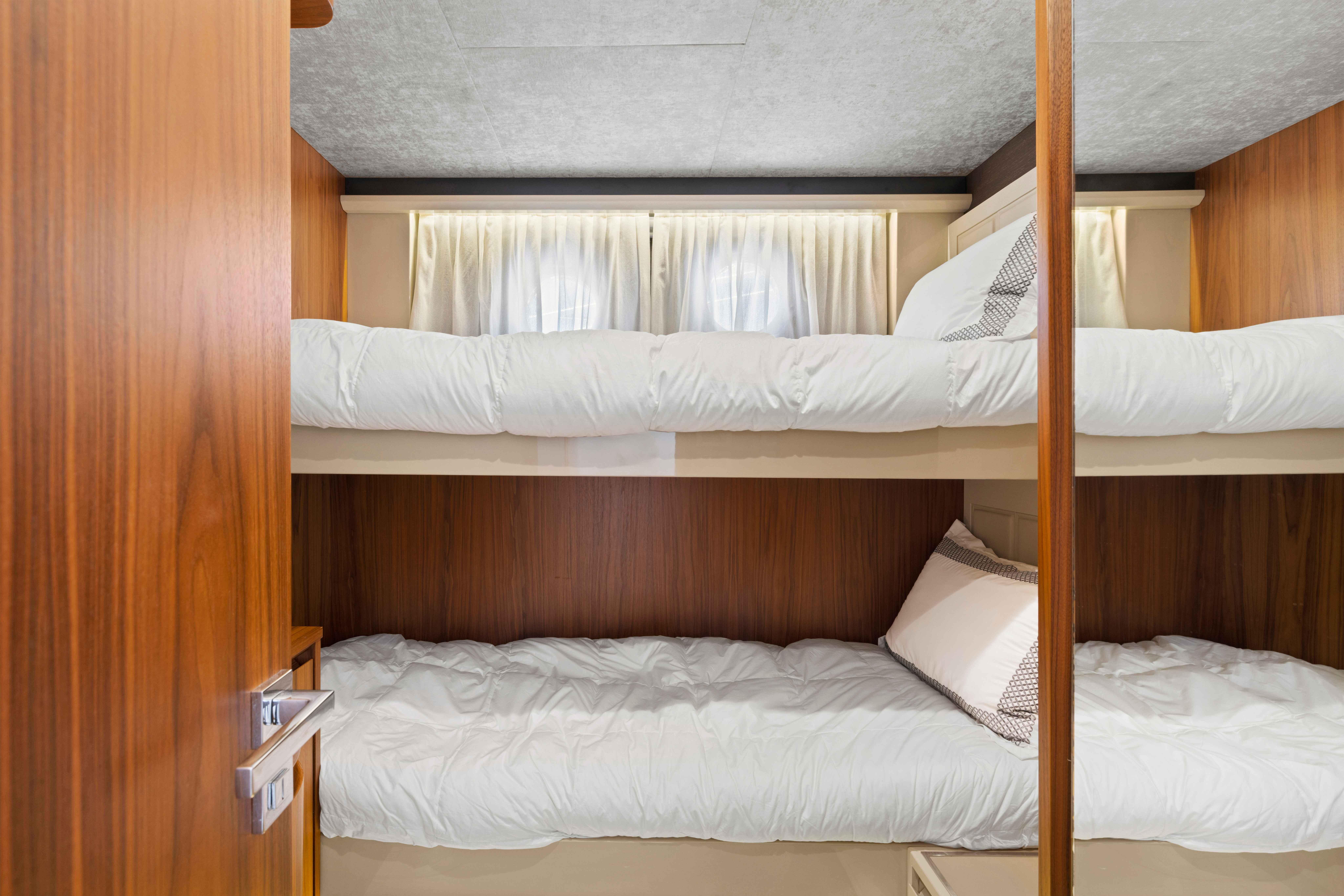 Bunk beds in a 2015 Absolute 64 FLY yacht cabin with wooden accents.