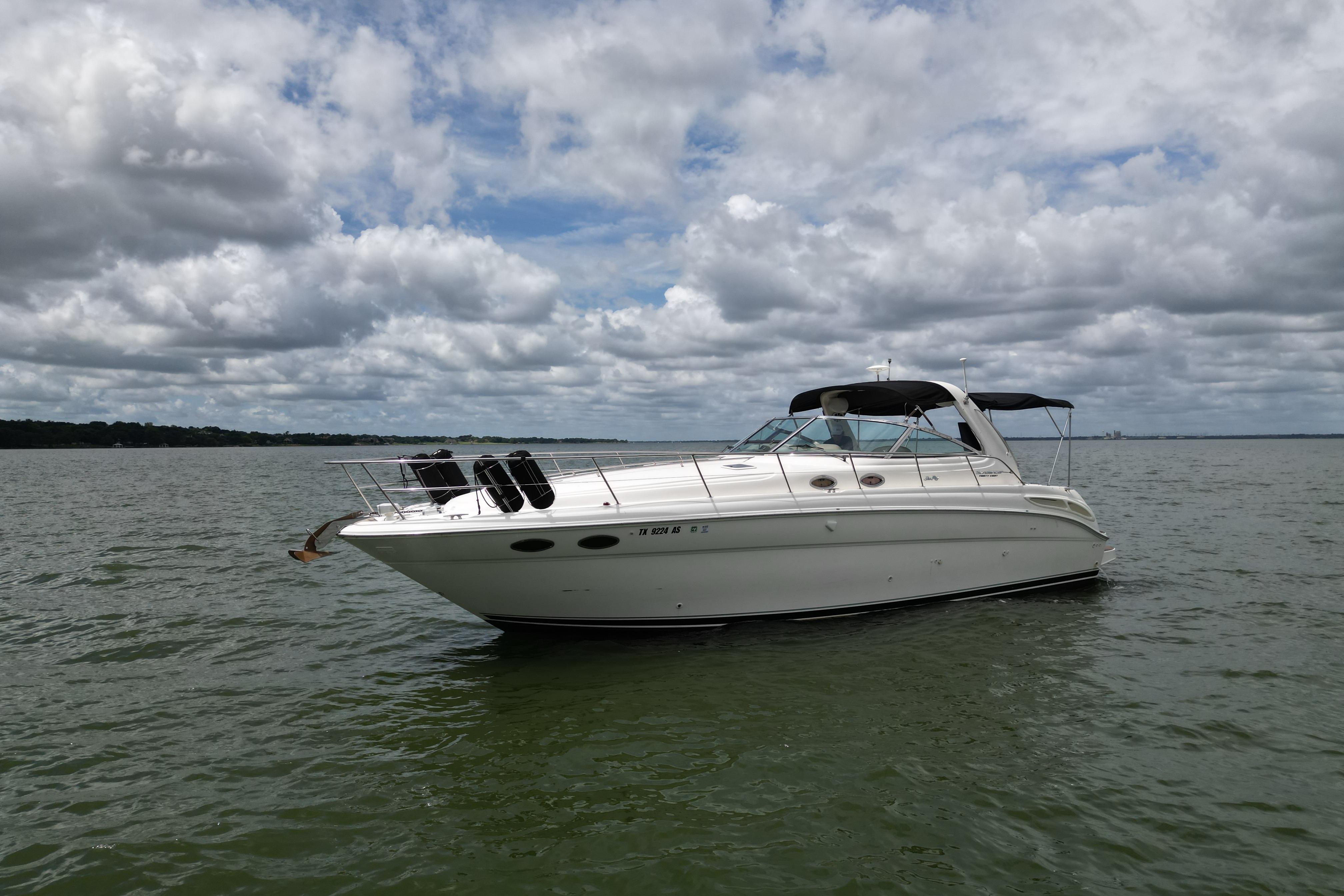 2001 Sea Ray 380 Sundancer yacht on calm water under cloudy sky.