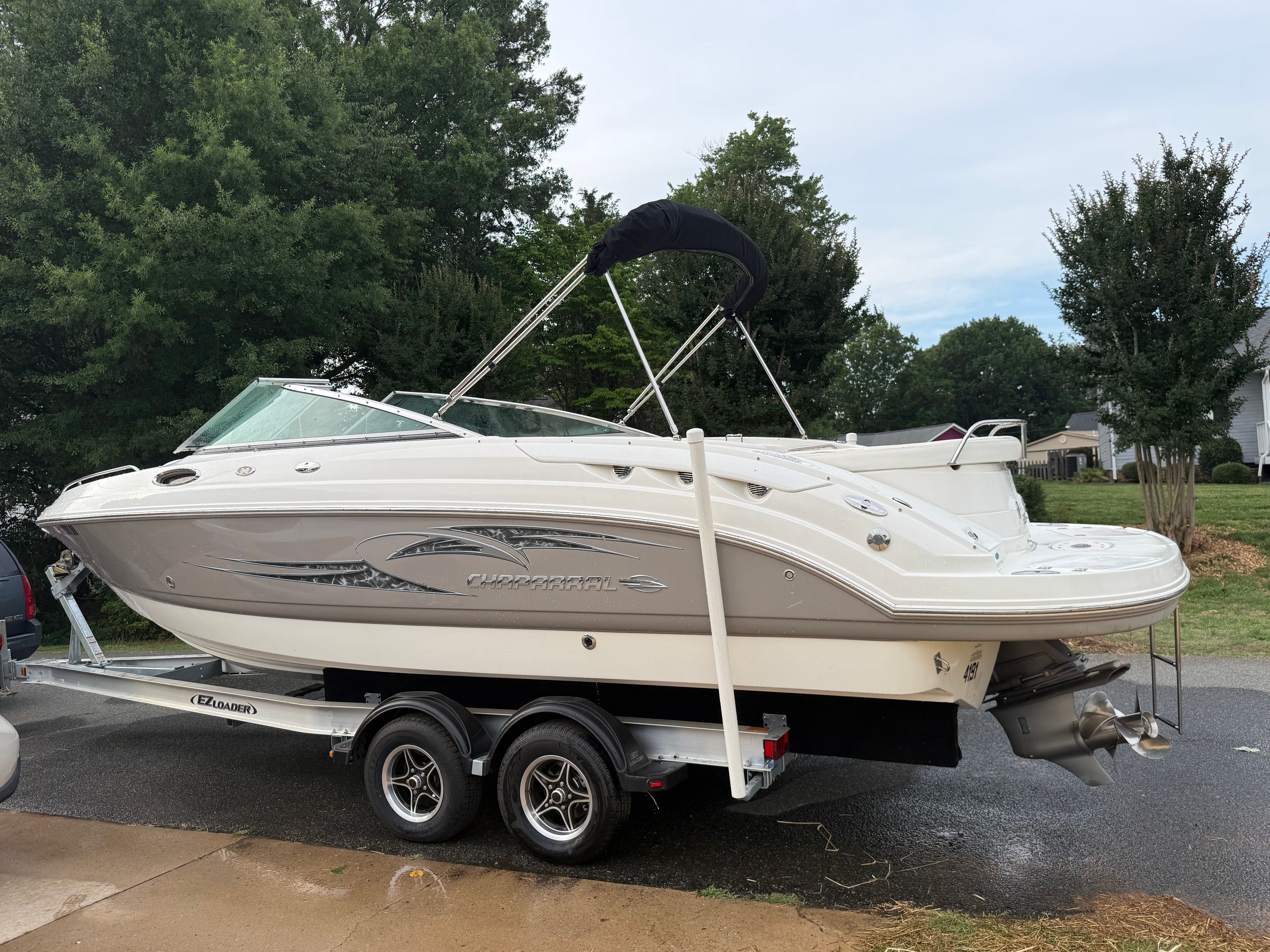 A 2007 Chaparral 256 SSX boat on a trailer, surrounded by trees.