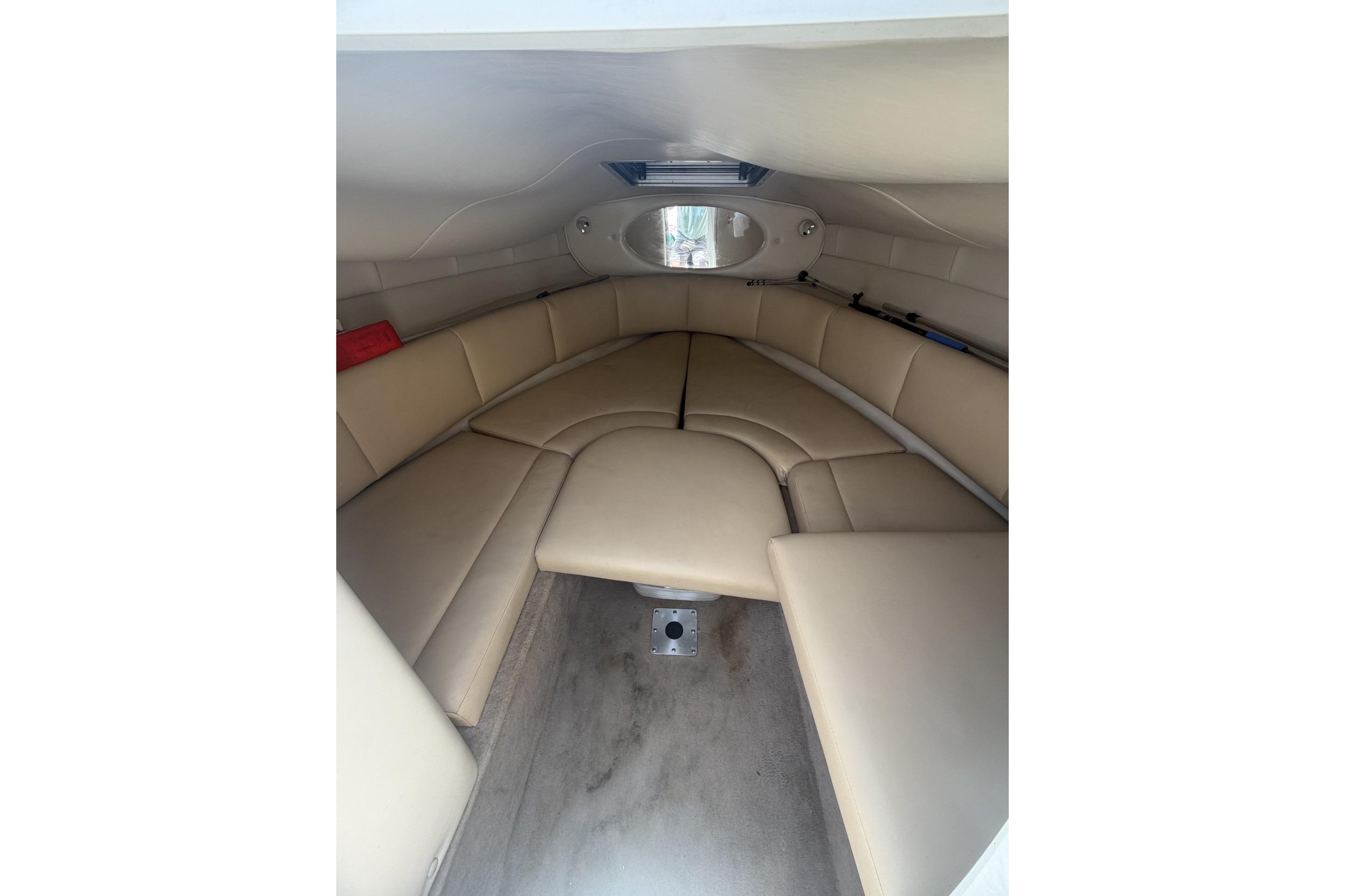 Interior cabin of 2001 Chaparral 235 SSi boat with beige seating and compact design.