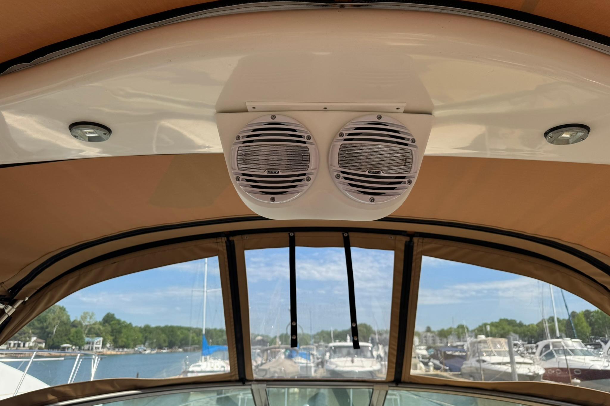 2001 Sea Ray 340 Sundancer boat speakers and canopy with marina view.