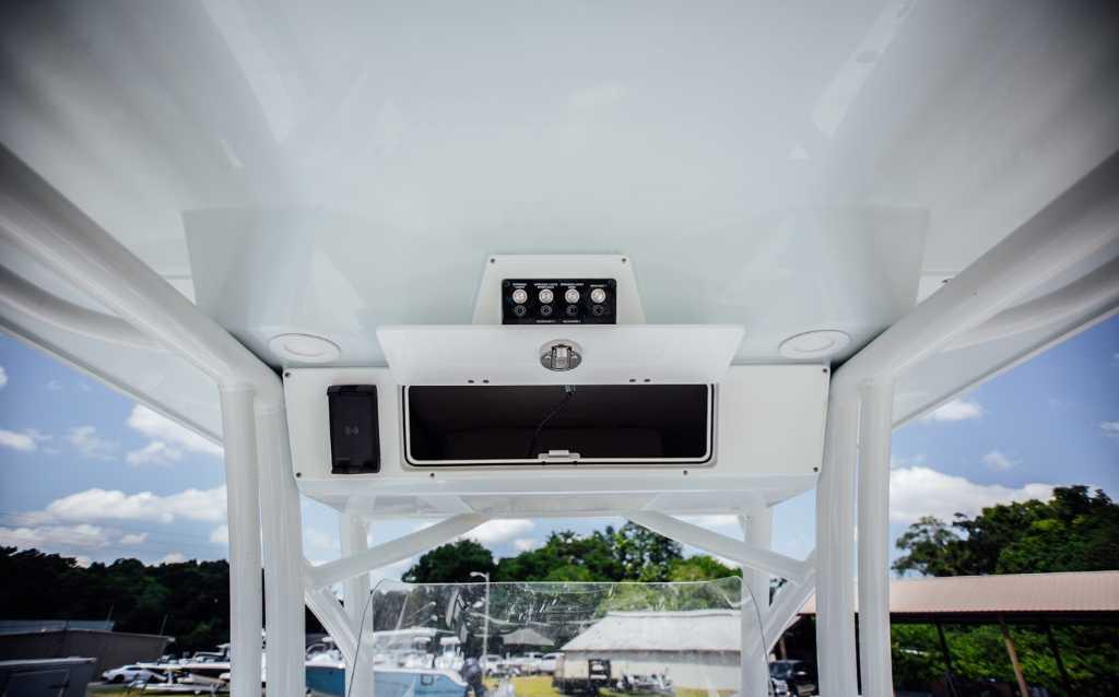 2021 Sea Fox 248 Commander boat console with storage and controls, under a clear blue sky.