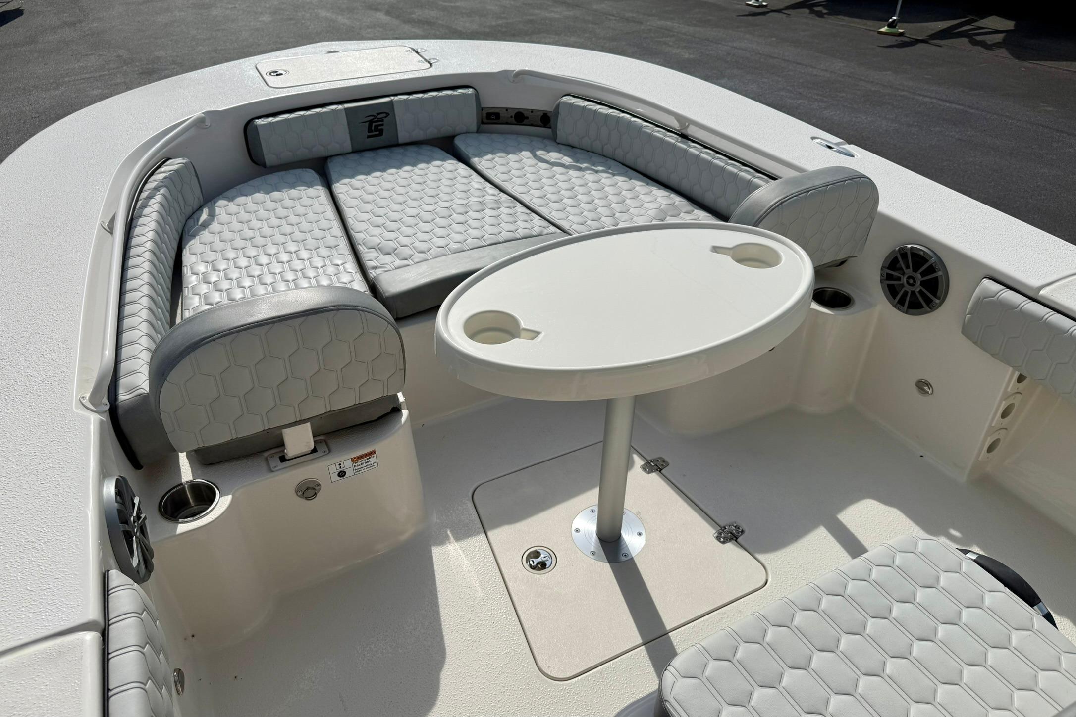 2026 Carolina Skiff 24 Ultra Elite boat interior with cushioned seating and round table.