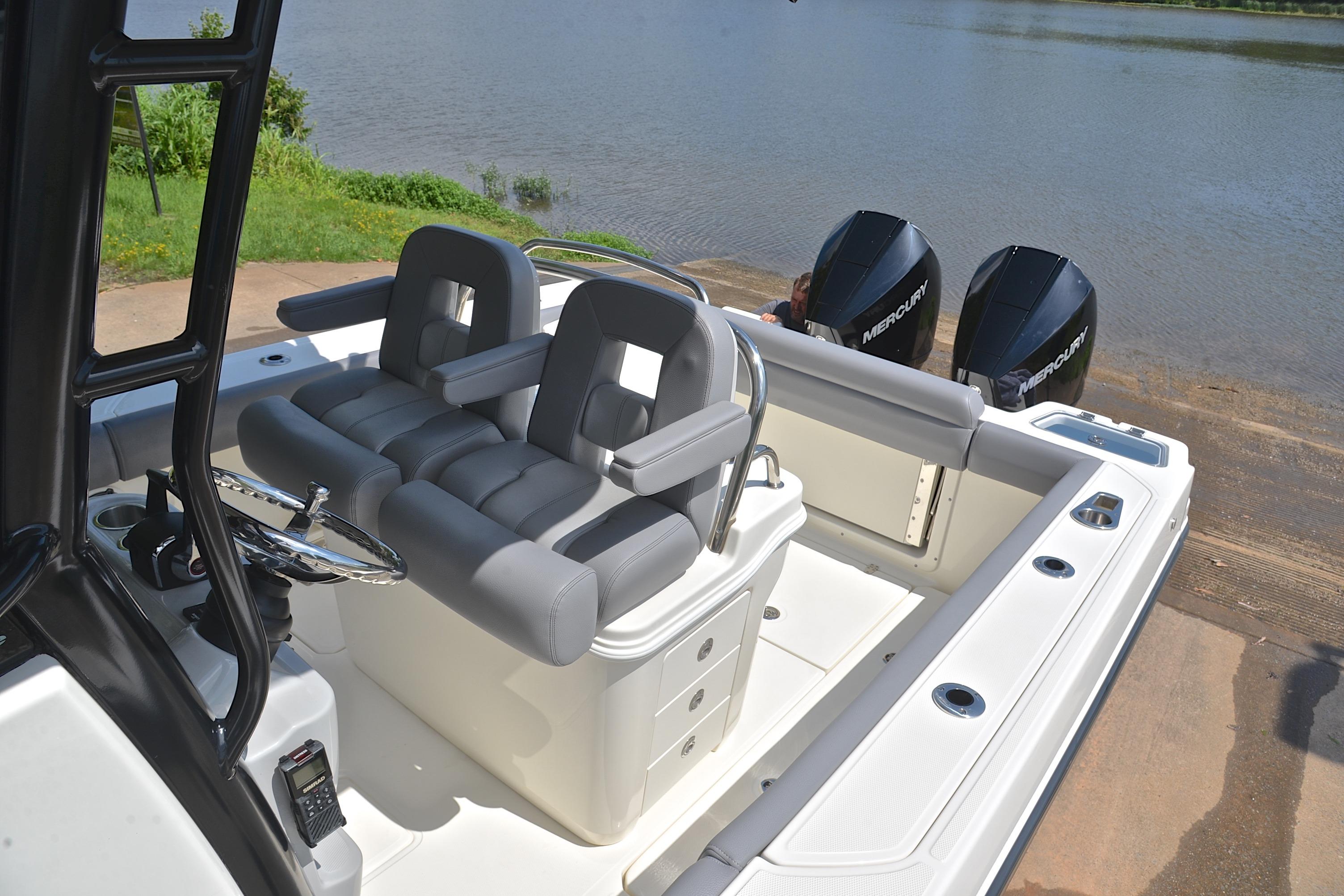 2024 Boston Whaler 250 Outrage boat interior with dual Mercury engines by the water.