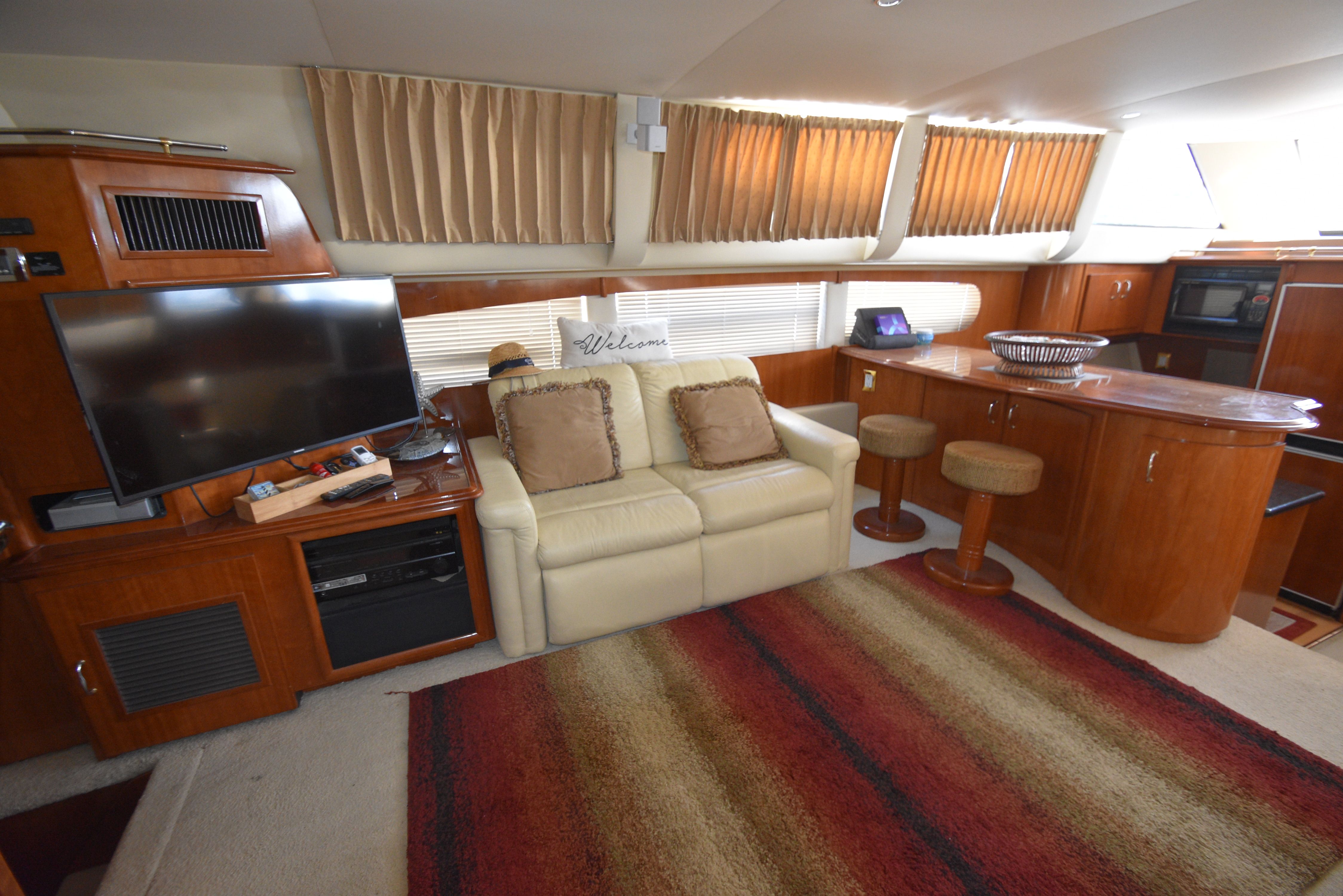 Interior of a 2004 Carver 466 Motor Yacht with sofa, TV, and bar area.