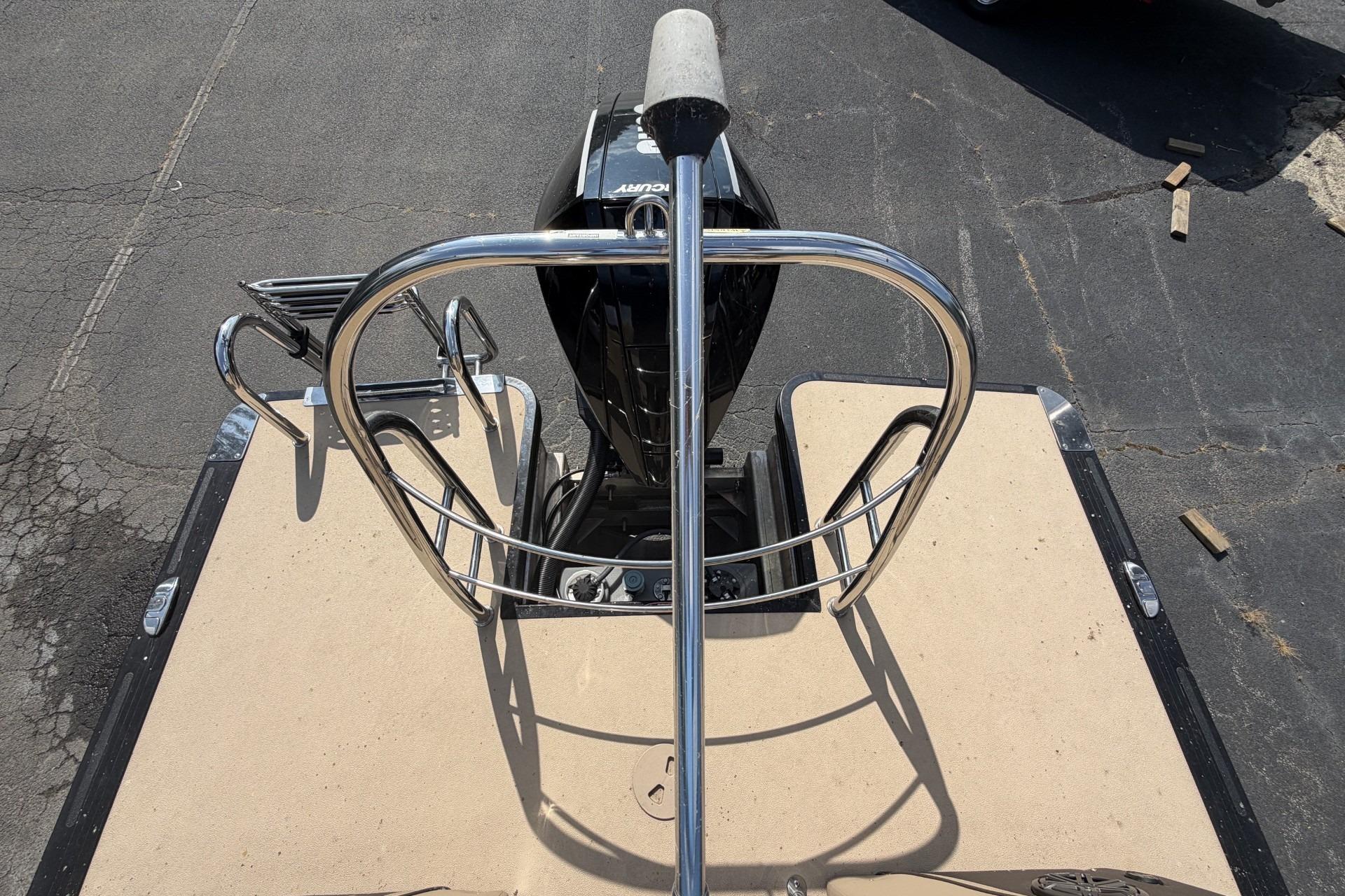 Rear view of 2022 Harris Solstice 230 CWDH boat with motor and railing.