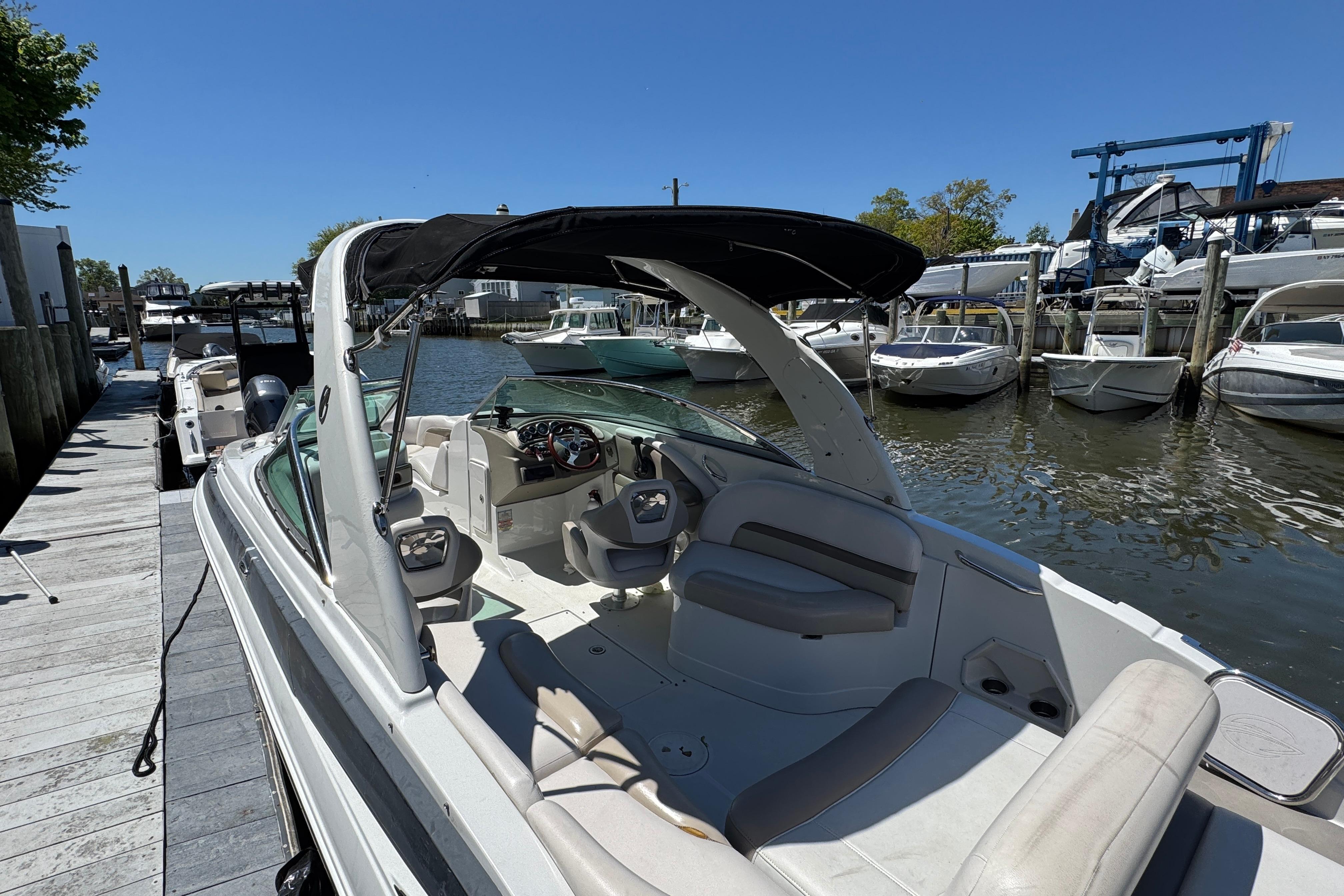 2013 Crownline Eclipse E6 XS boat docked at marina, featuring spacious seating and sleek design.
