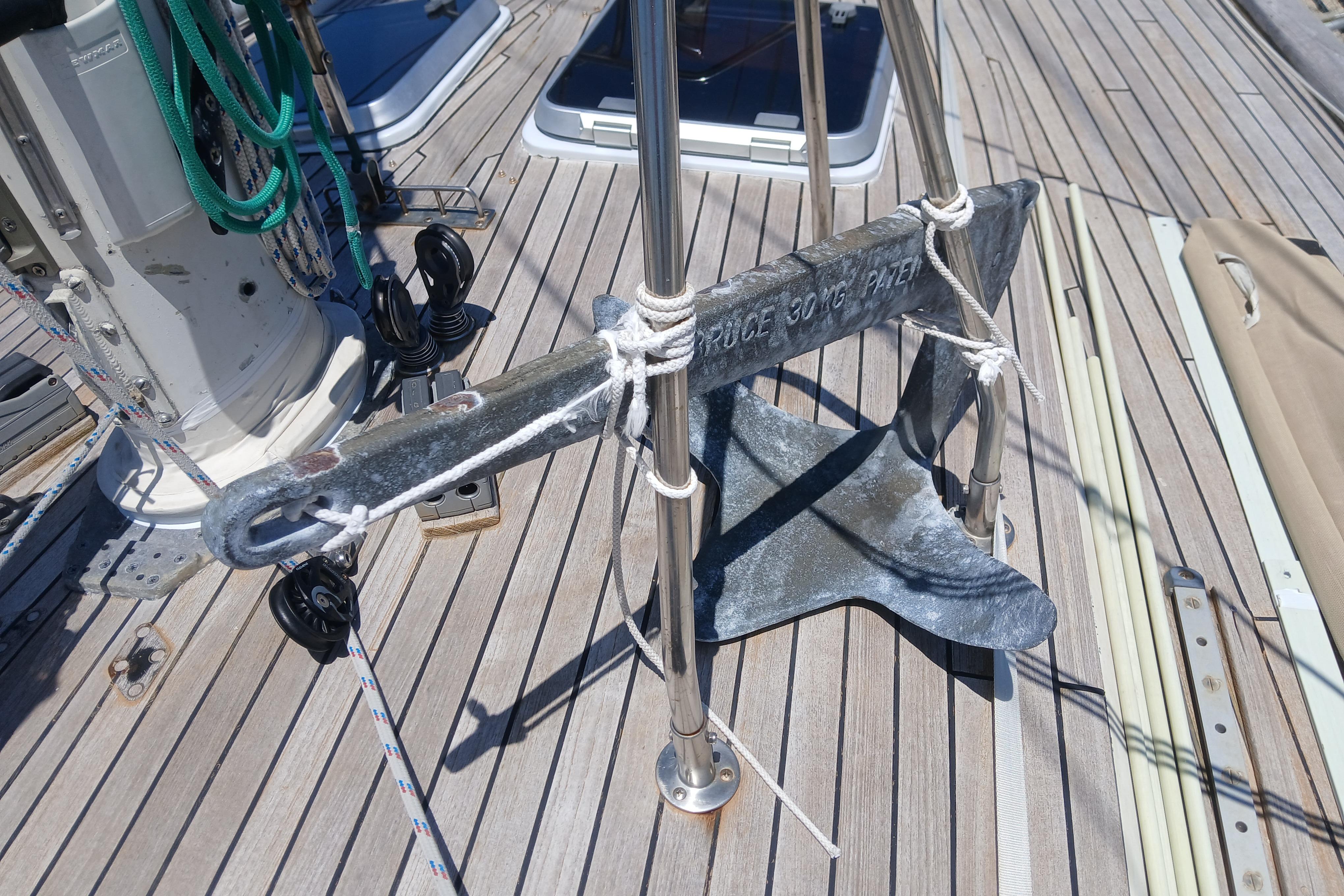 Anchor on deck of 1981 Kaufman Skye 51 sailboat, secured with ropes.