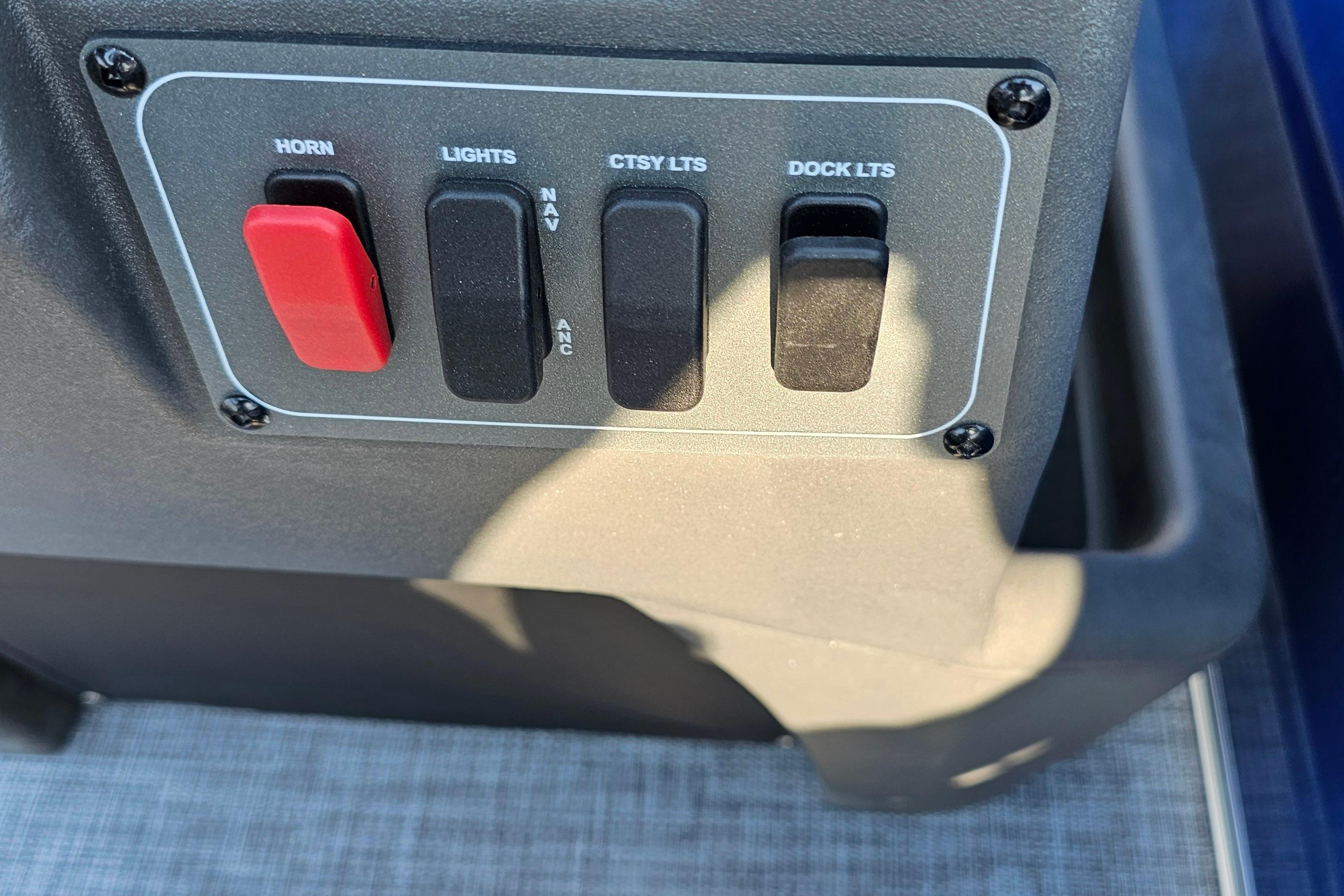 Control panel of 2026 Sun Tracker Party Barge 16 DLX with switches for horn and lights.