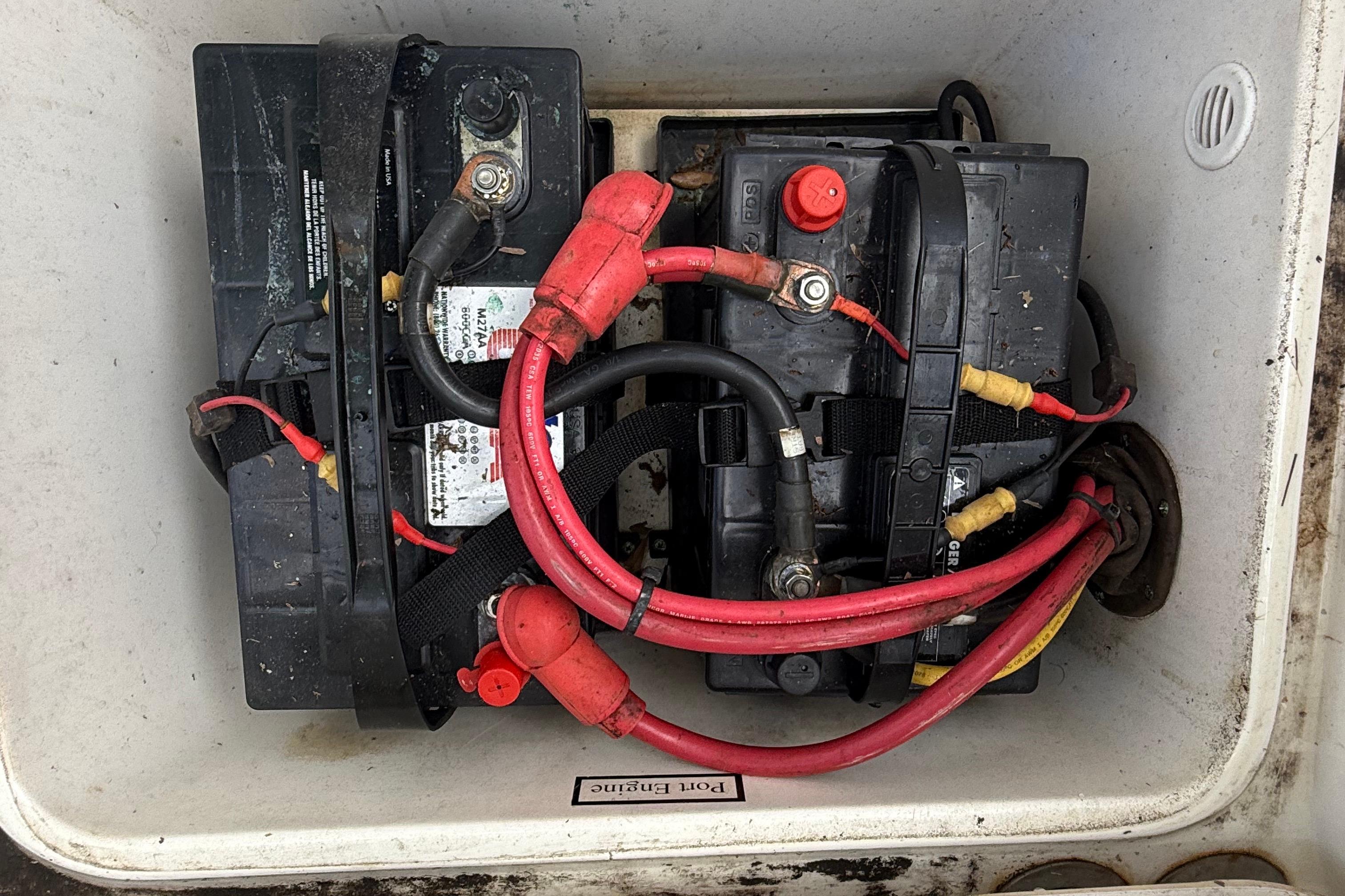 Two marine batteries with red and black cables in a 2008 Century 2901 Center Console.