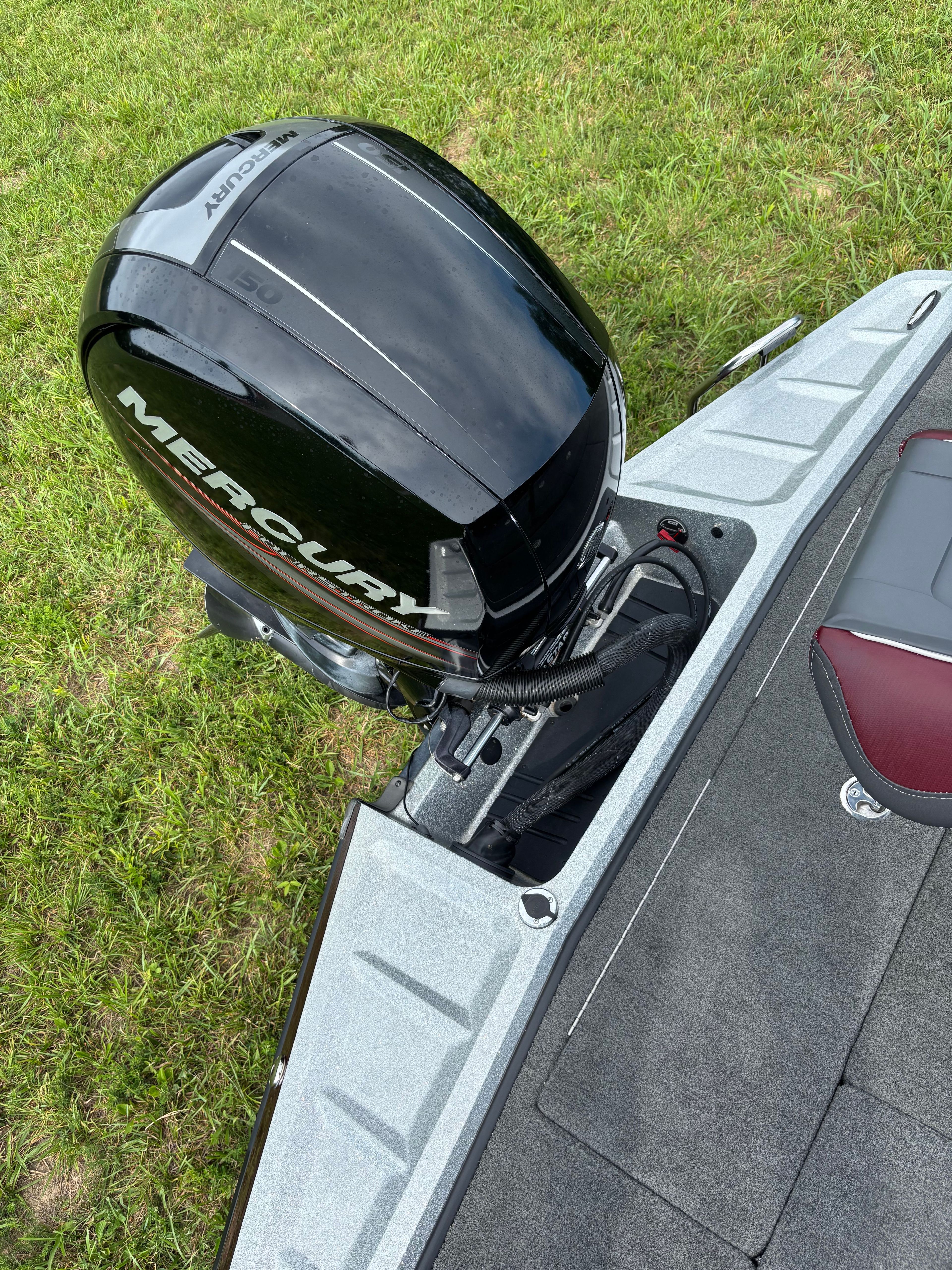 A Ranger Z 185 boat with a Mercury outboard motor on grass.