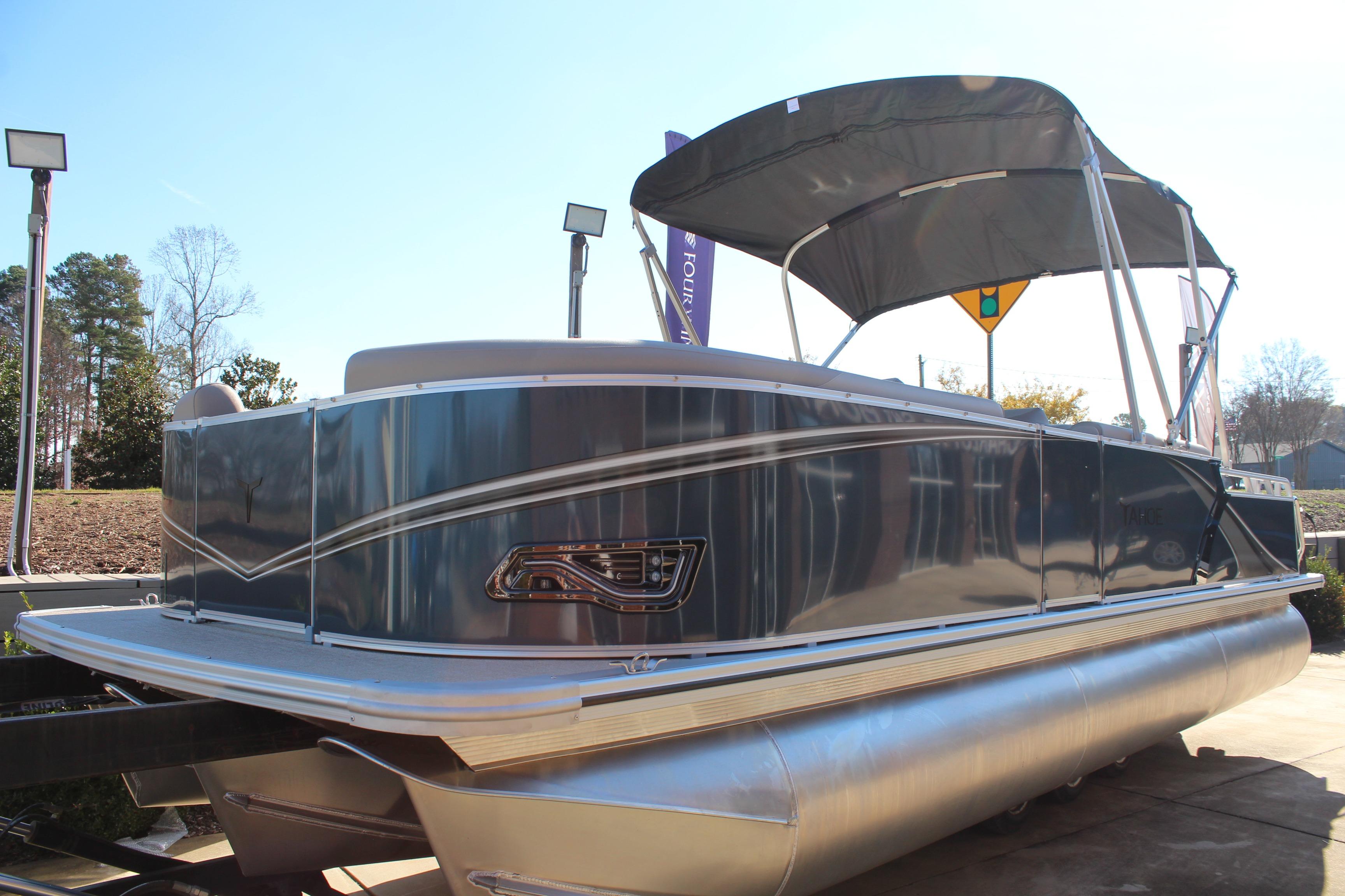 2026 Tahoe Pontoon LTZ Elite boat with canopy, parked outdoors.