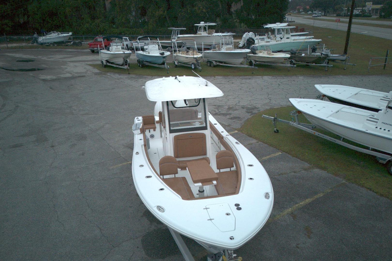 2026 Sea Hunt Gamefish 25 boat in a parking lot with other boats.