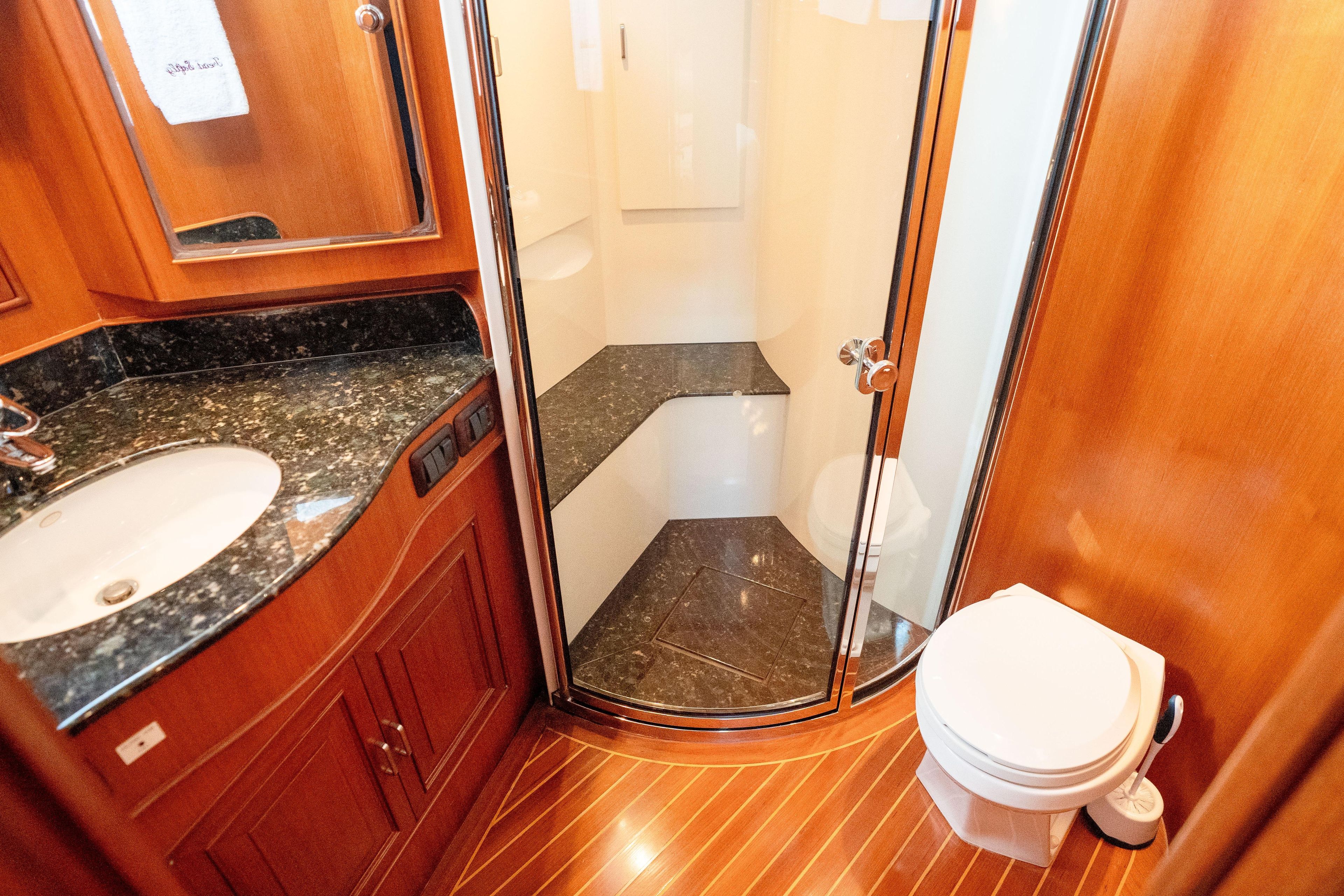 Luxurious bathroom in 2006 Fleming 75 yacht with wood accents and granite countertop.
