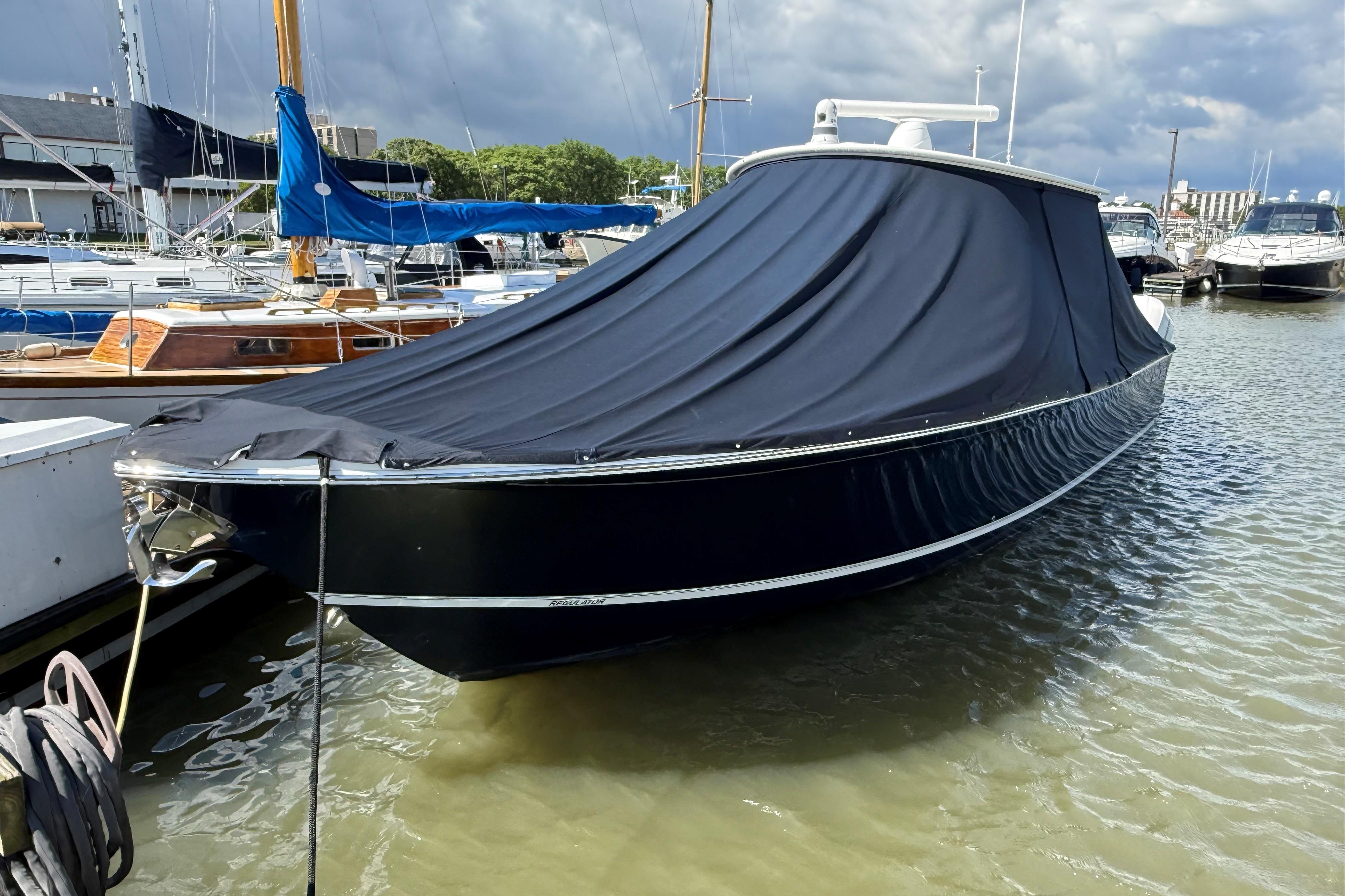 2019 Regulator 34SS boat docked with protective cover in a marina.