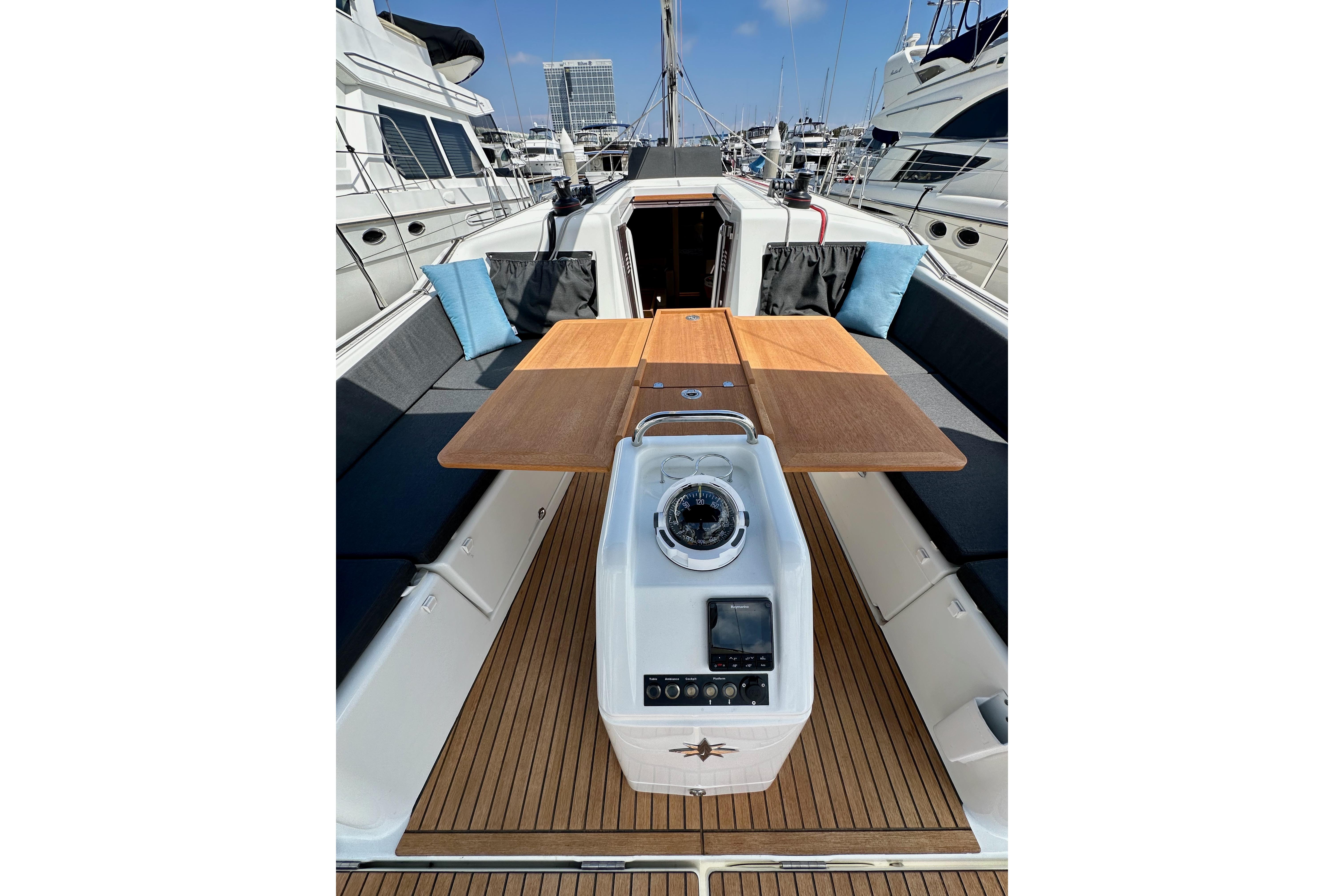 2024 Jeanneau Sun Odyssey 410 sailboat cockpit with wooden table and navigation equipment.