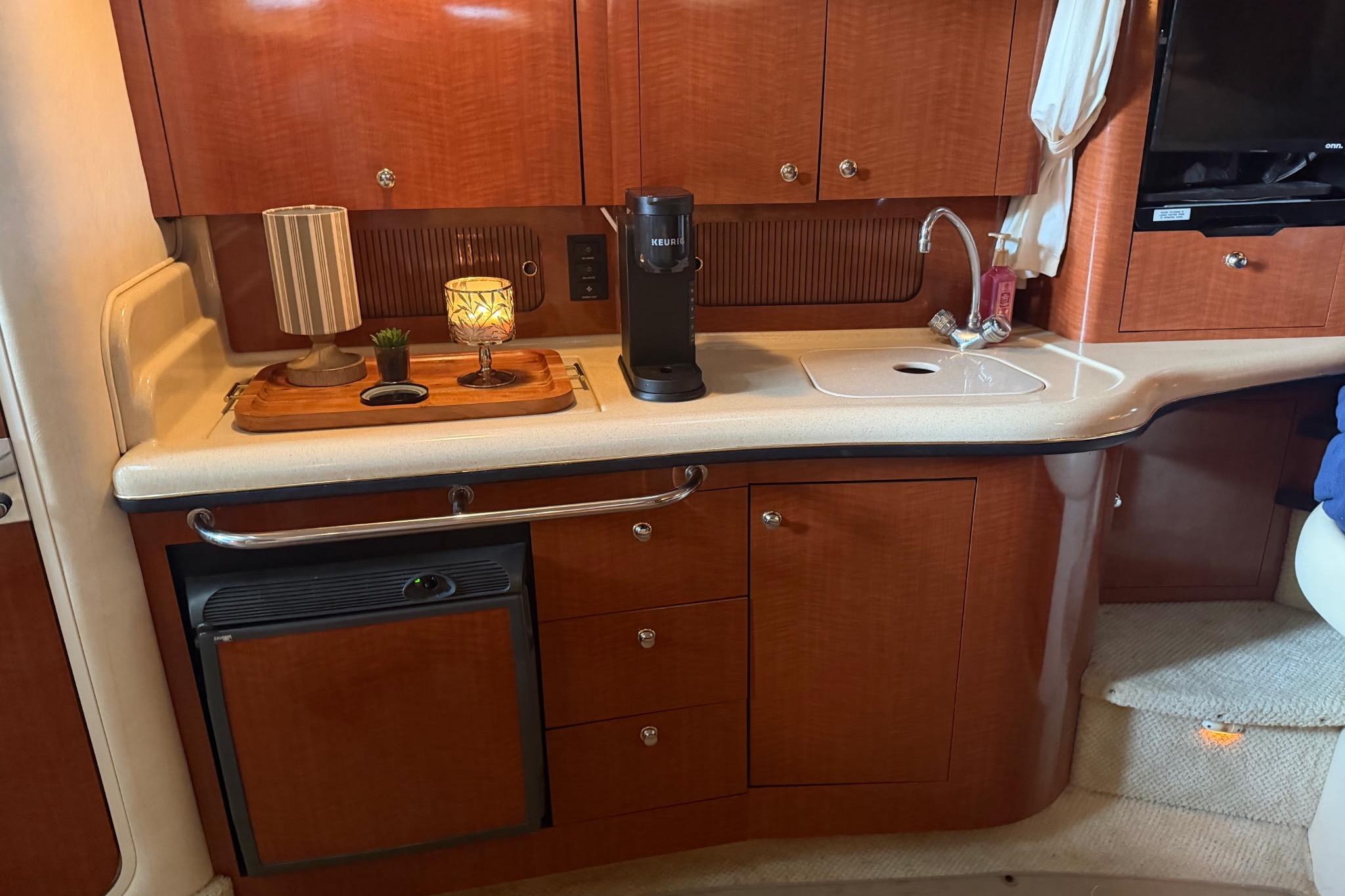 Interior of a 2002 Sea Ray Sundancer 320 yacht with kitchenette and appliances.