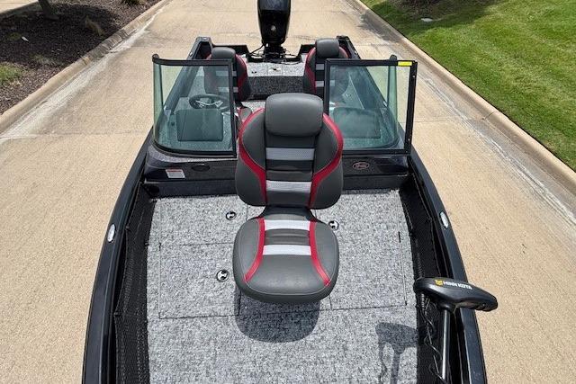 2026 Ranger VS1782SC Angler boat with dual windshields and cushioned seating on a paved road.