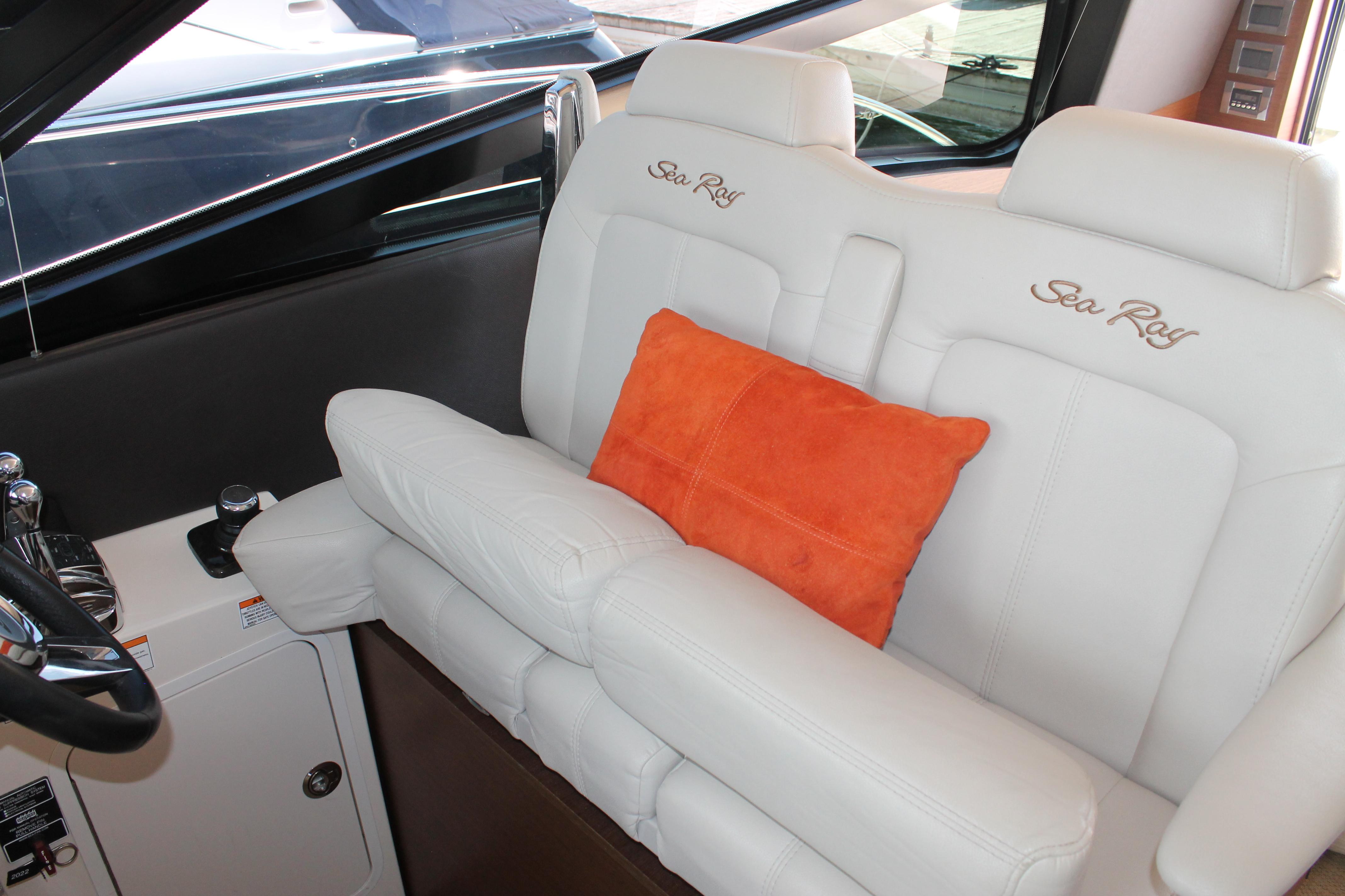 2015 Sea Ray 470 Sundancer interior with white seating and orange cushion.