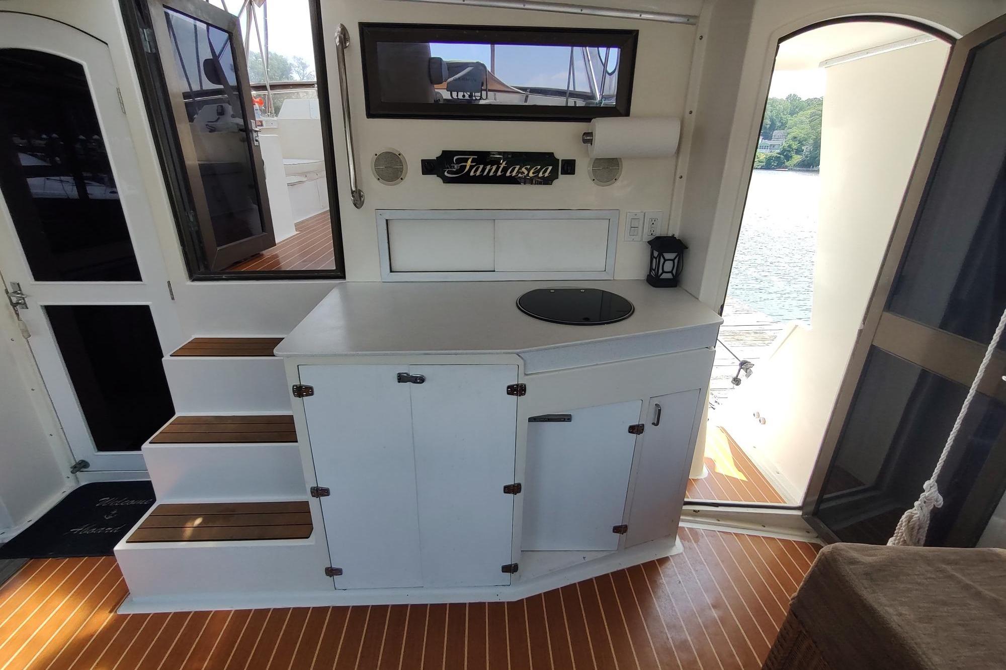 1989 Hyatt Double Cabin Motoryacht interior with kitchenette and steps, featuring "Fantasea" sign.