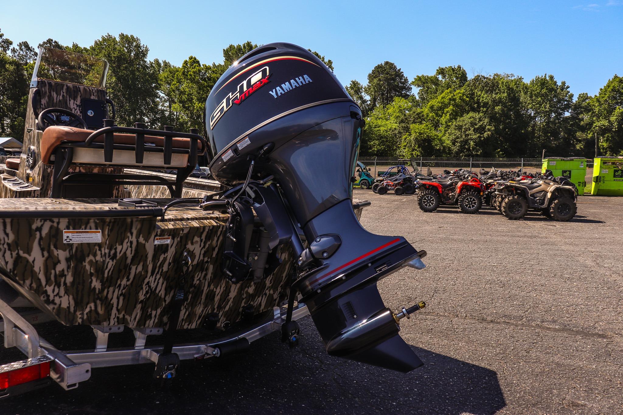 Avid 20 Rogue CC 2027 with Yamaha outboard motor on a trailer, surrounded by trees and ATVs.