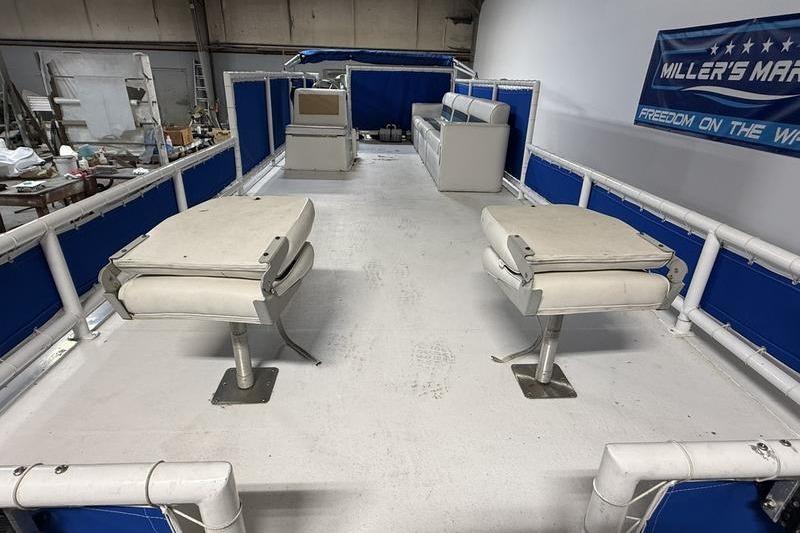 1993 Monark Sun Caster 240 CR 4 Point pontoon boat interior with seating and blue accents.