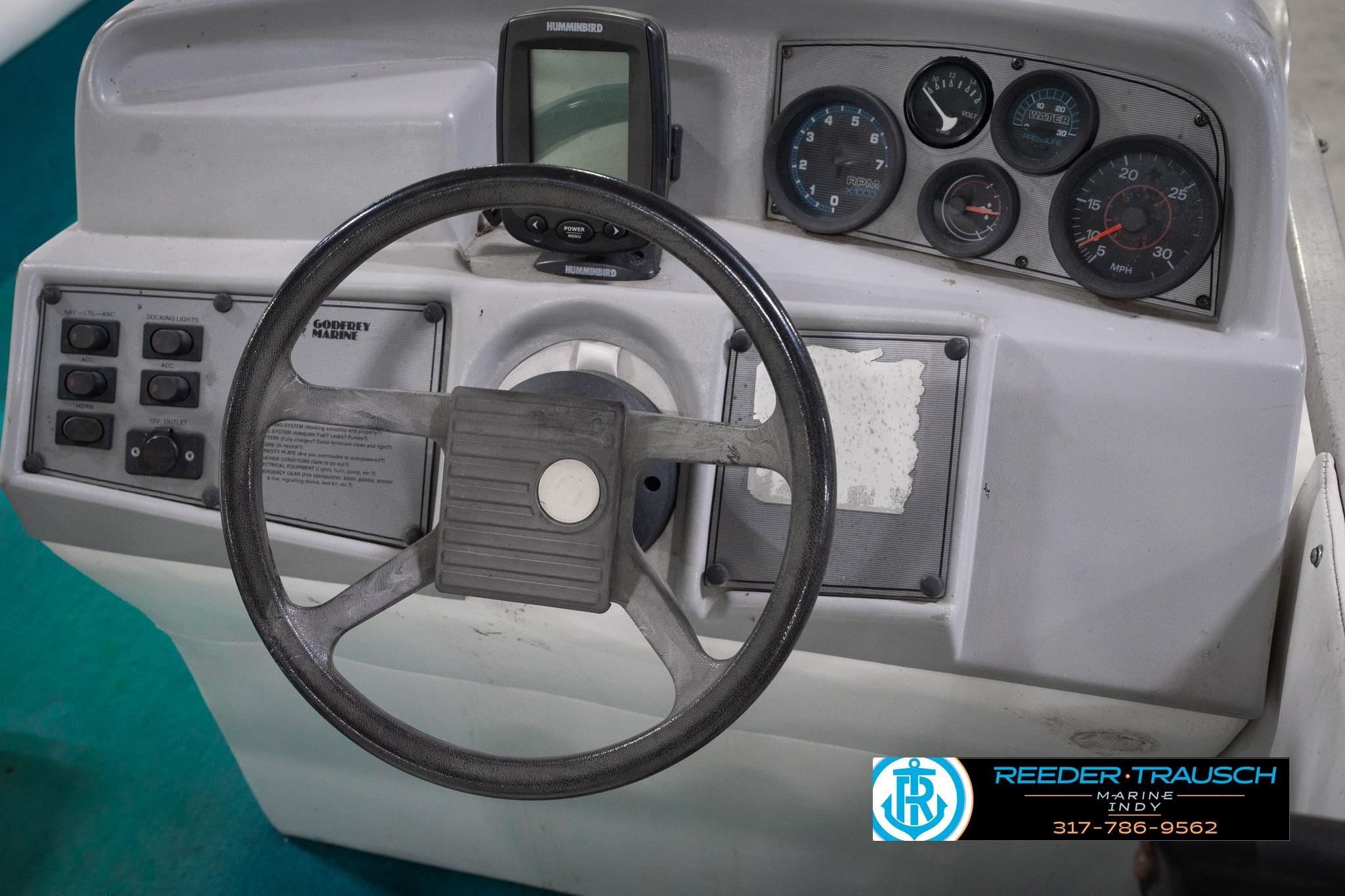 1992 Godfrey Sweetwater boat dashboard with steering wheel and gauges.