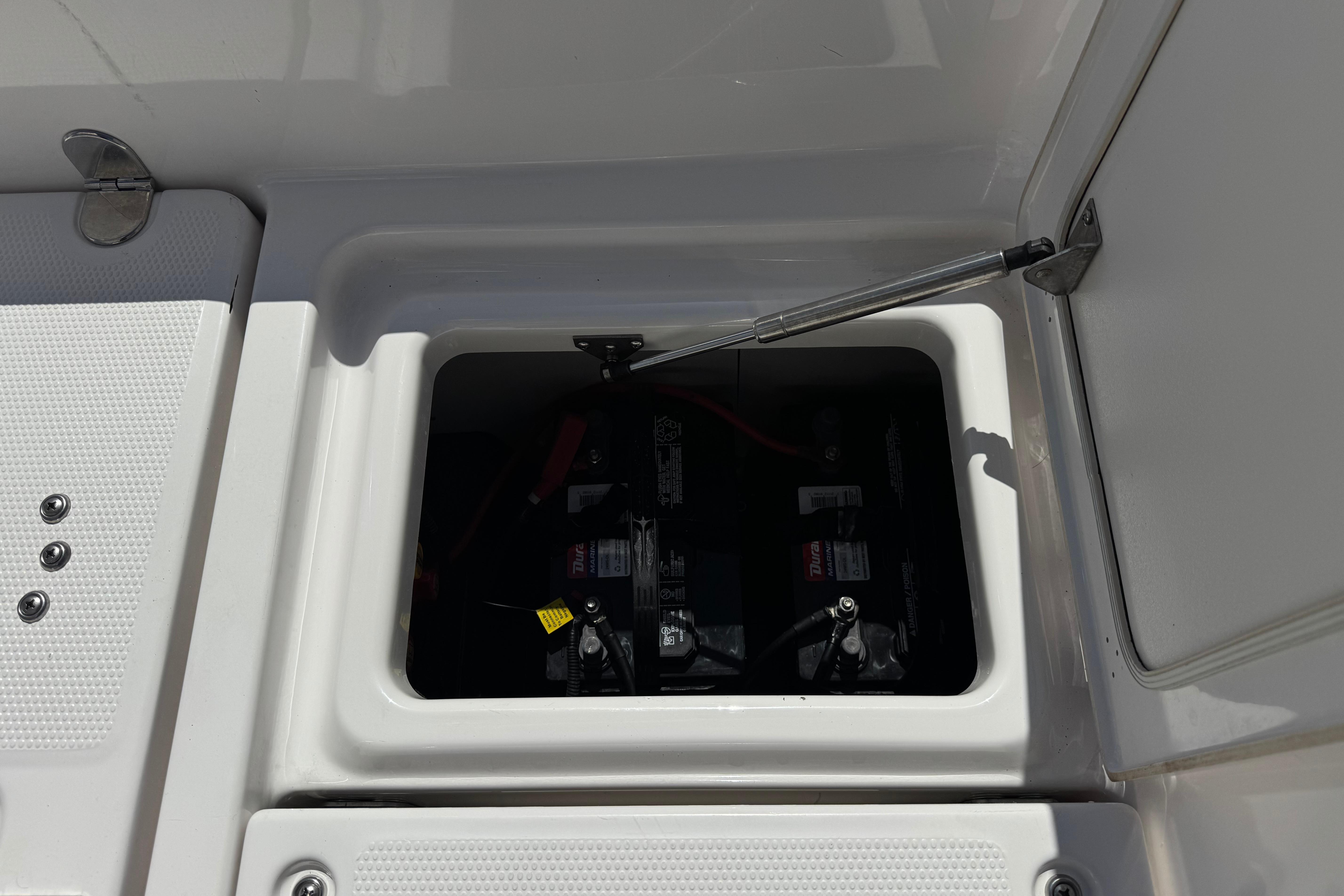 Battery compartment of 2016 Yamaha Boats 190 FSH Deluxe, open hatch view.