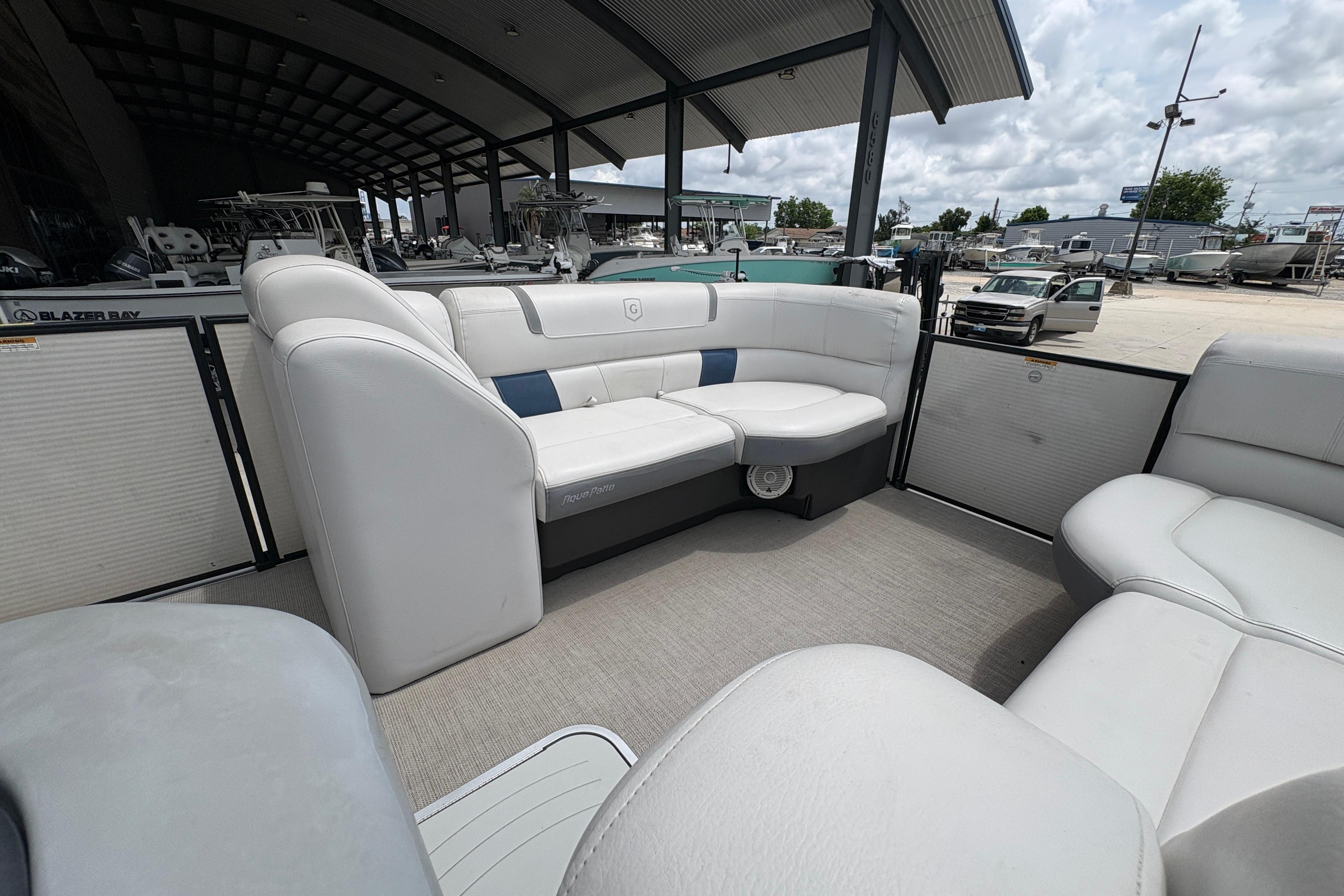 2019 Godfrey Aqua Patio boat interior with white seating, docked at a marina.