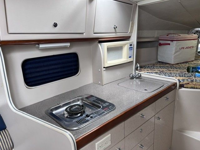 Interior of a 1999 Doral 300sc with kitchenette, stove, and sink.