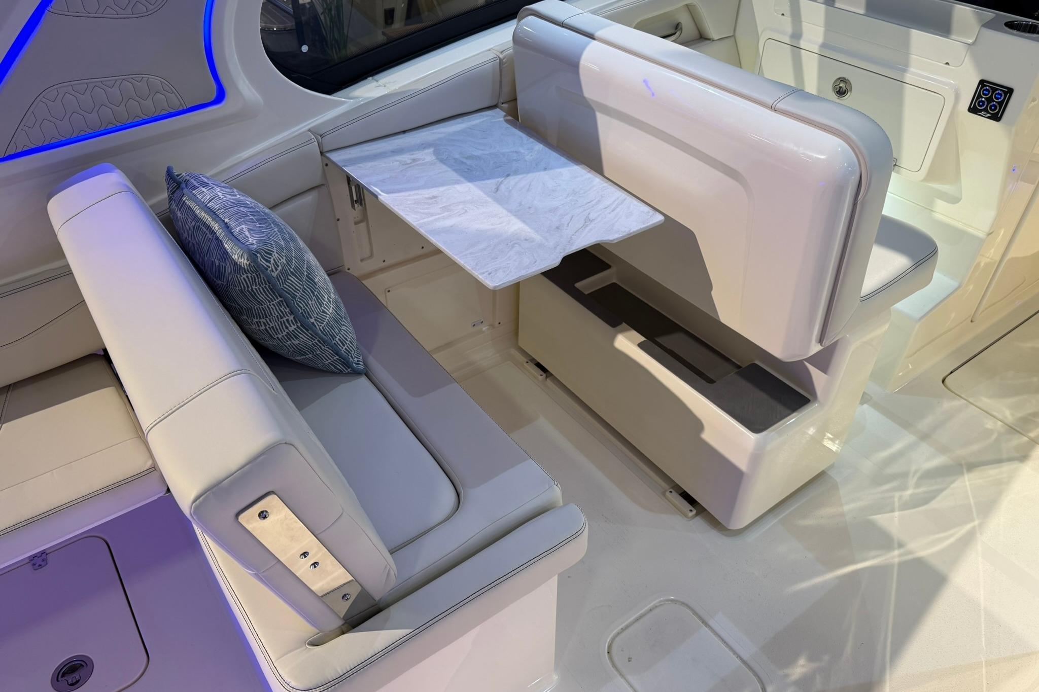 2026 Scout 288 Dorado boat interior with white seating and a foldable table.