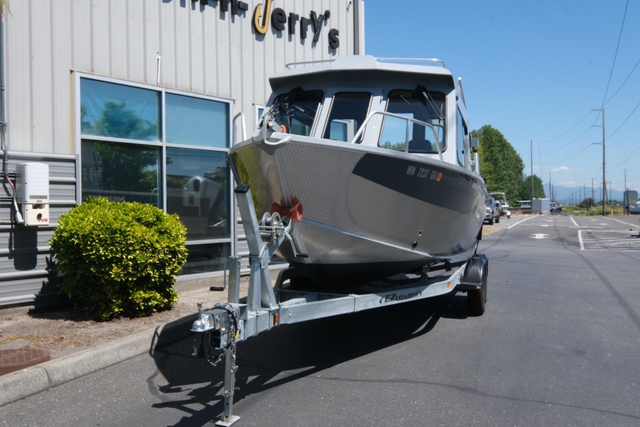 2018 Hewescraft 220 Ocean Pro ET Hardtop boat on trailer, parked outside a building.