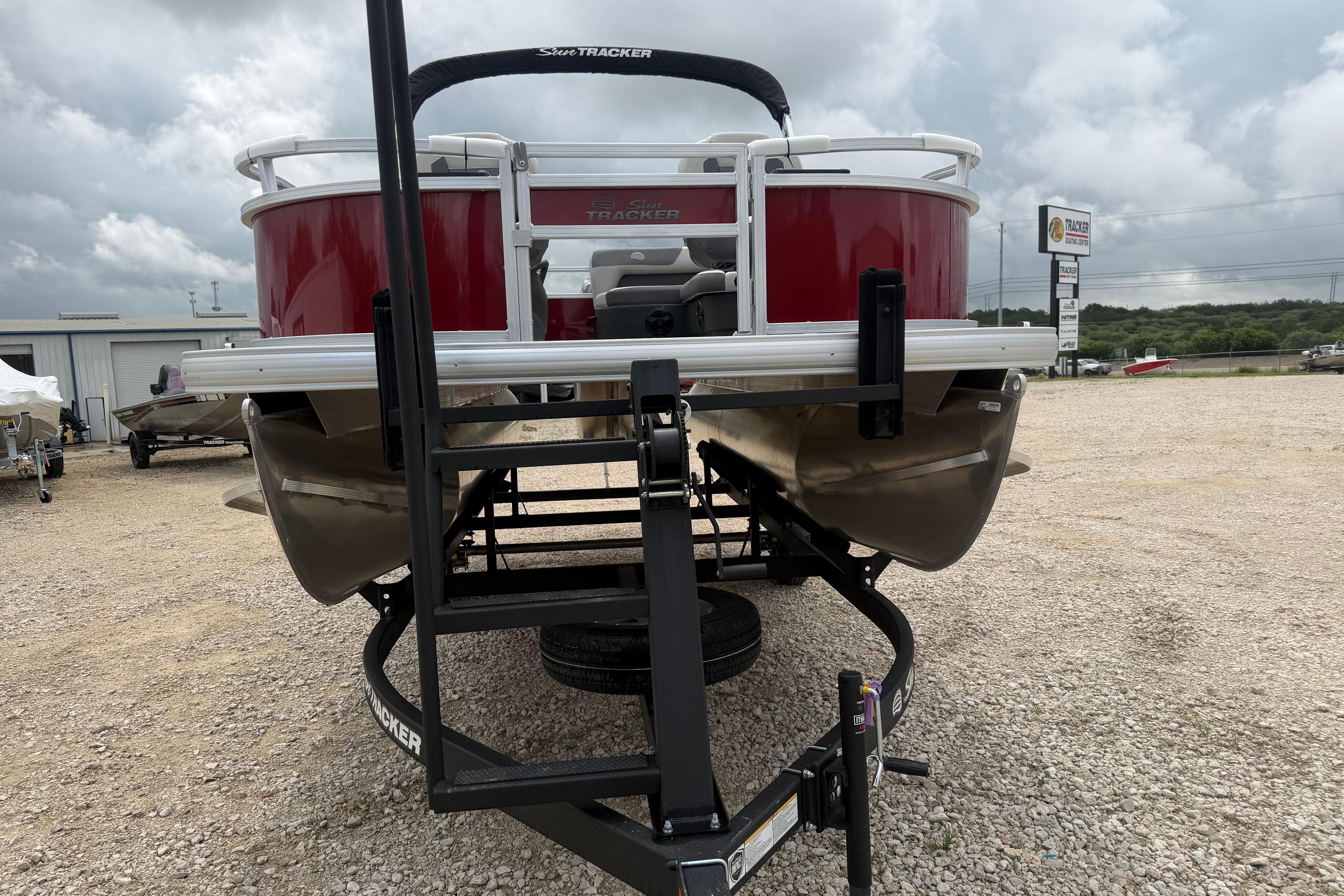 2026 Sun Tracker Bass Buggy 16 XL Select pontoon boat on trailer, outdoor display.