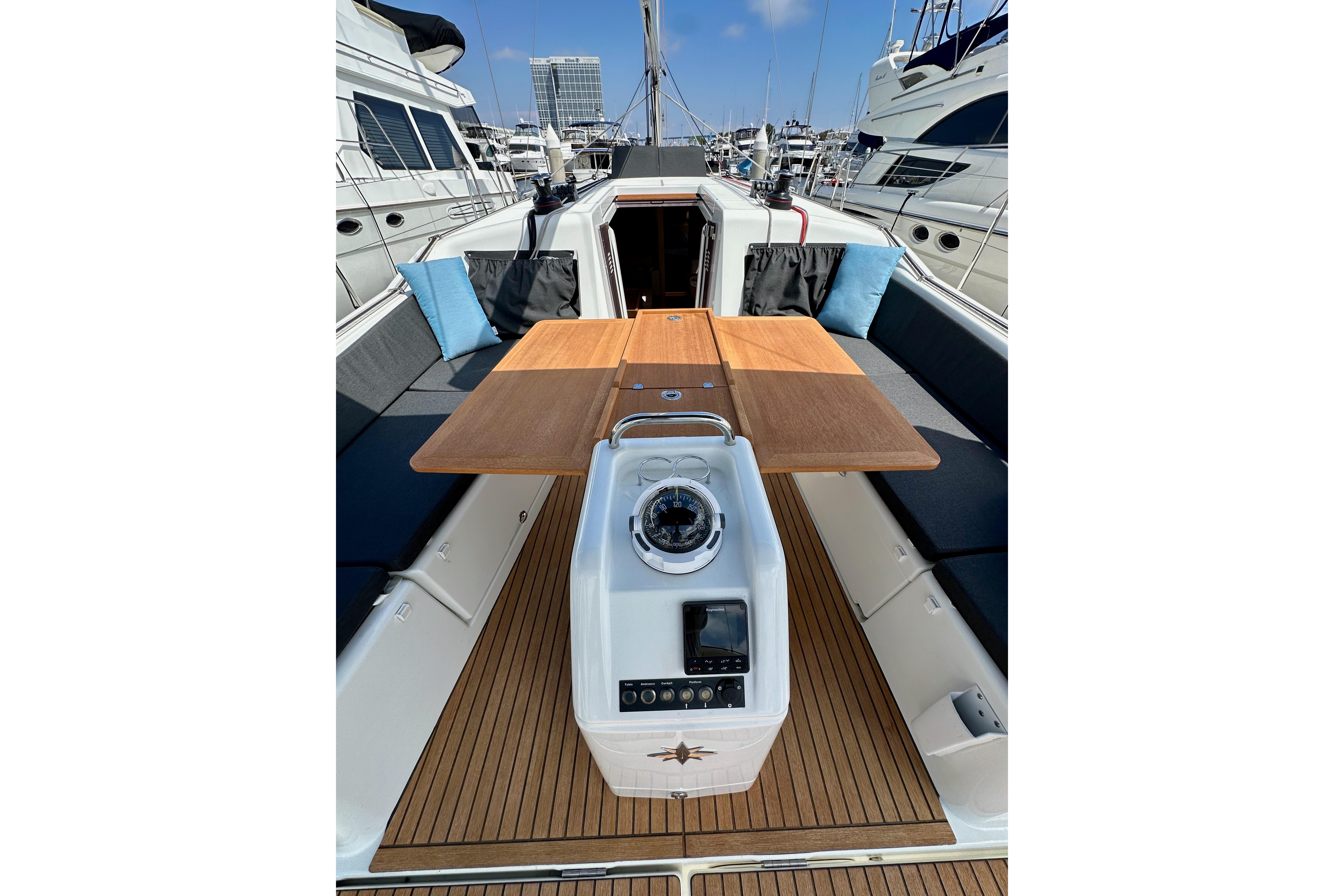 2024 Jeanneau Sun Odyssey 410 yacht cockpit with wooden table and seating.