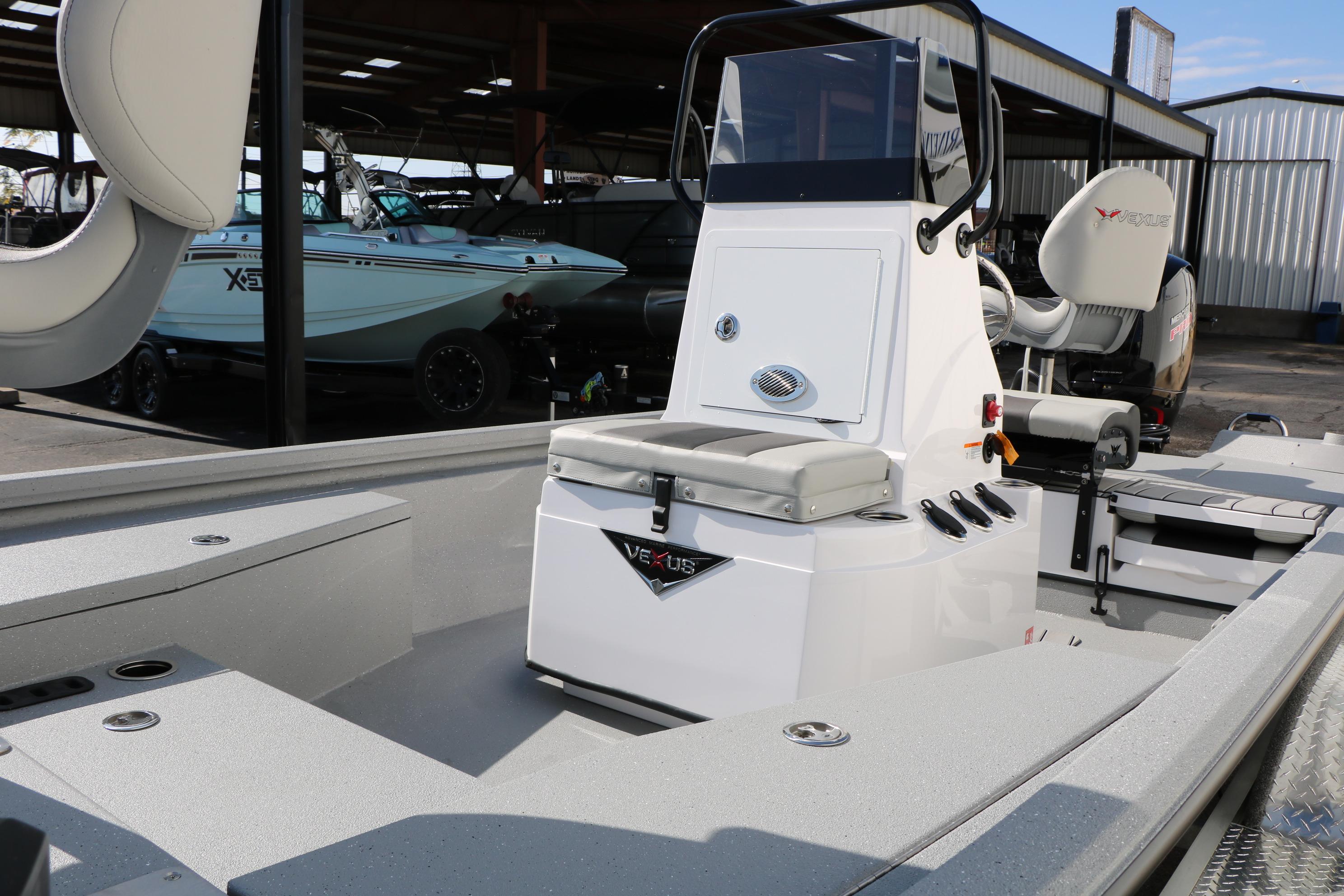 2026 Vexus ACX2000 boat interior with console and seating in a showroom.