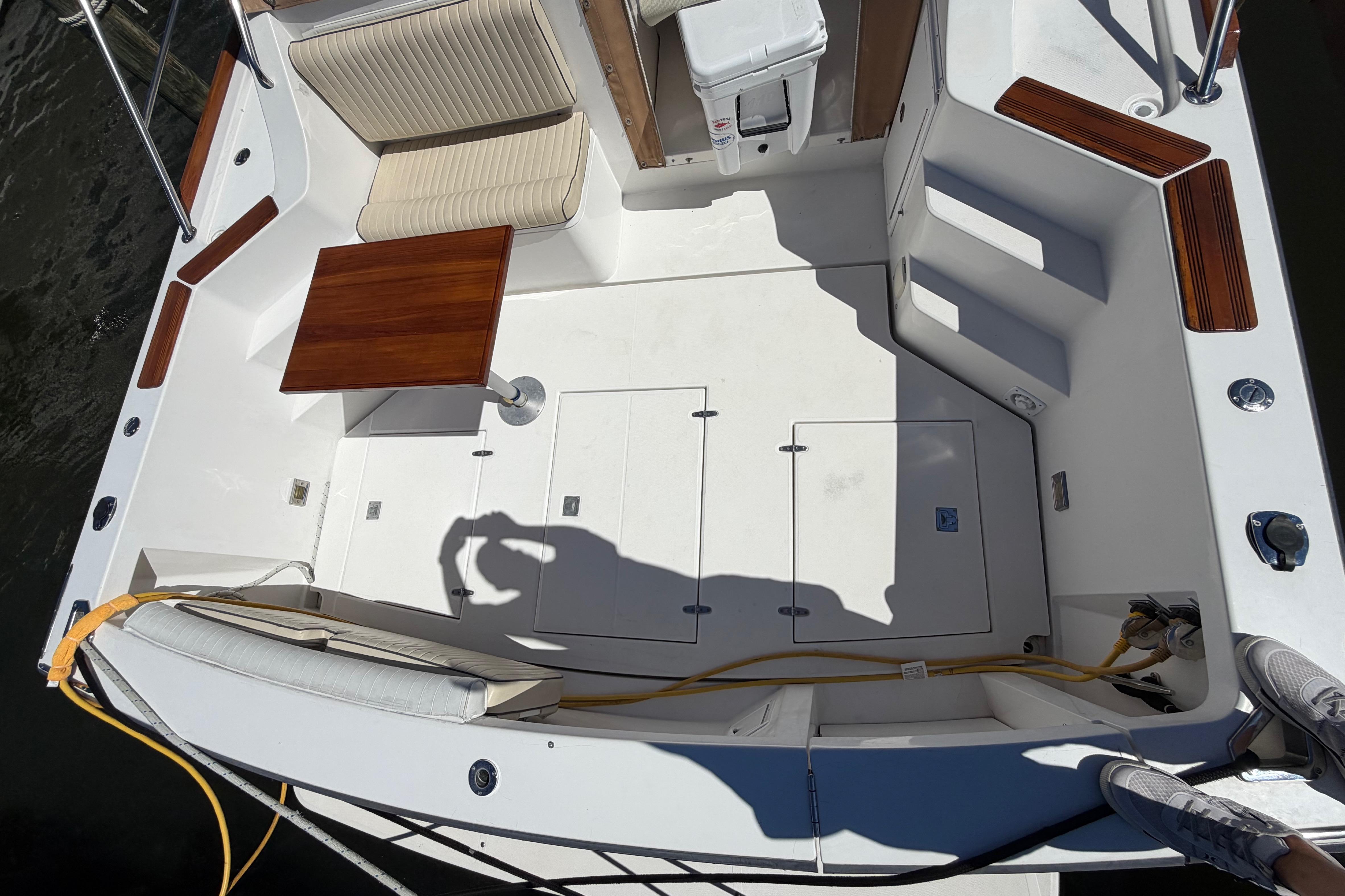 2000 Sabreline 36 Express boat deck with seating, table, and storage compartments.