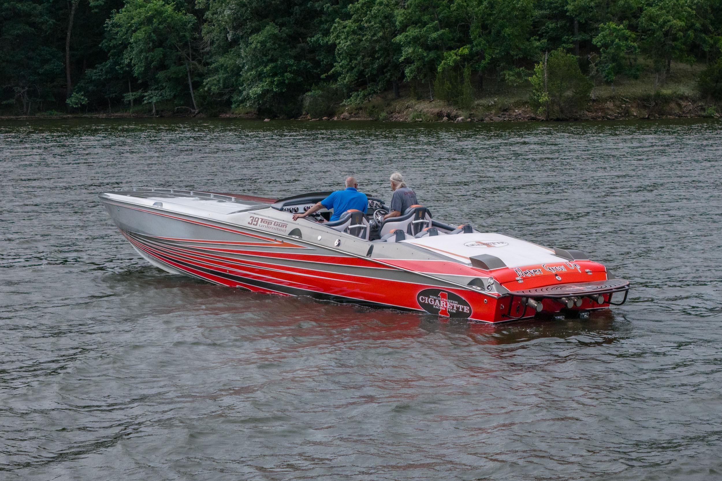 2006 Cigarette 39' Top Gun speedboat on a lake with lush green shoreline.
