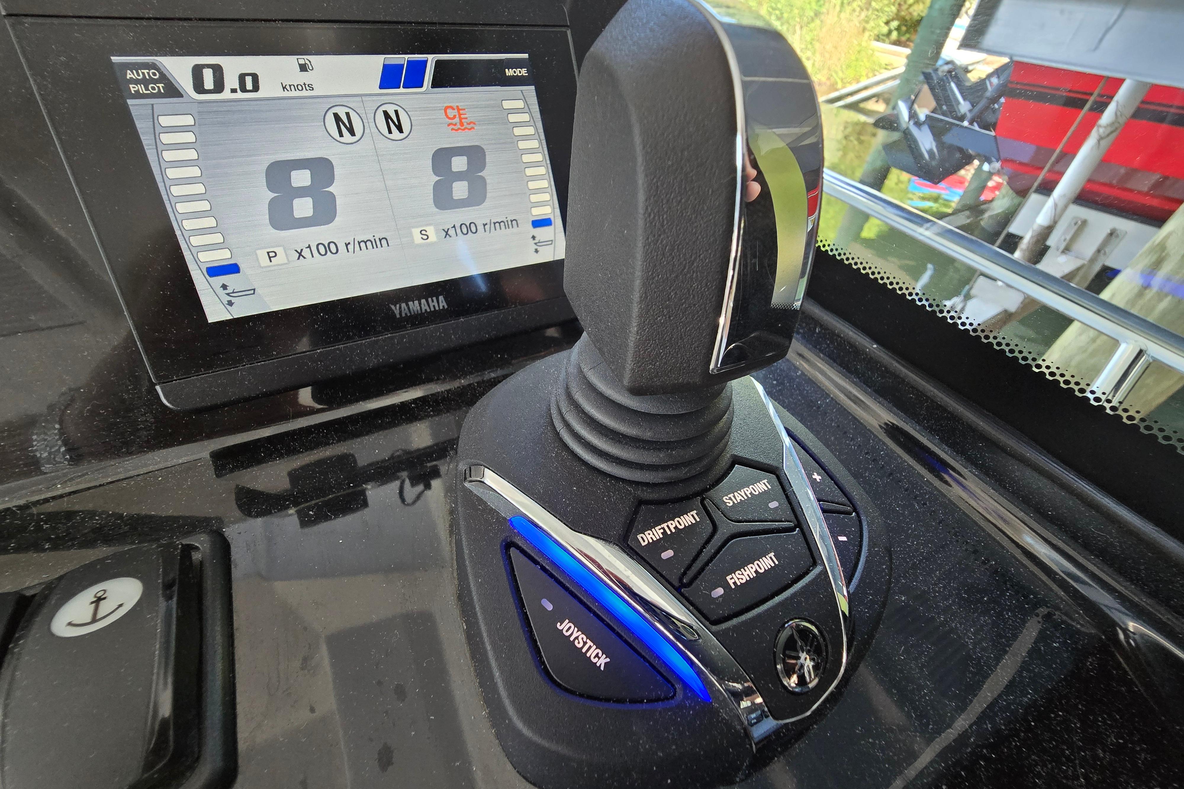 Close-up of a modern boat control system with joystick and digital display.