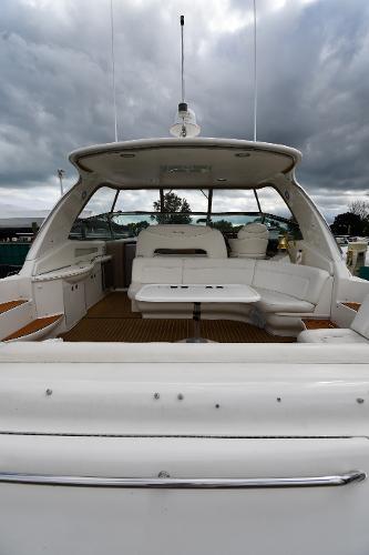2003 Sea Ray 460 Sundancer yacht with spacious deck and seating area under cloudy skies.