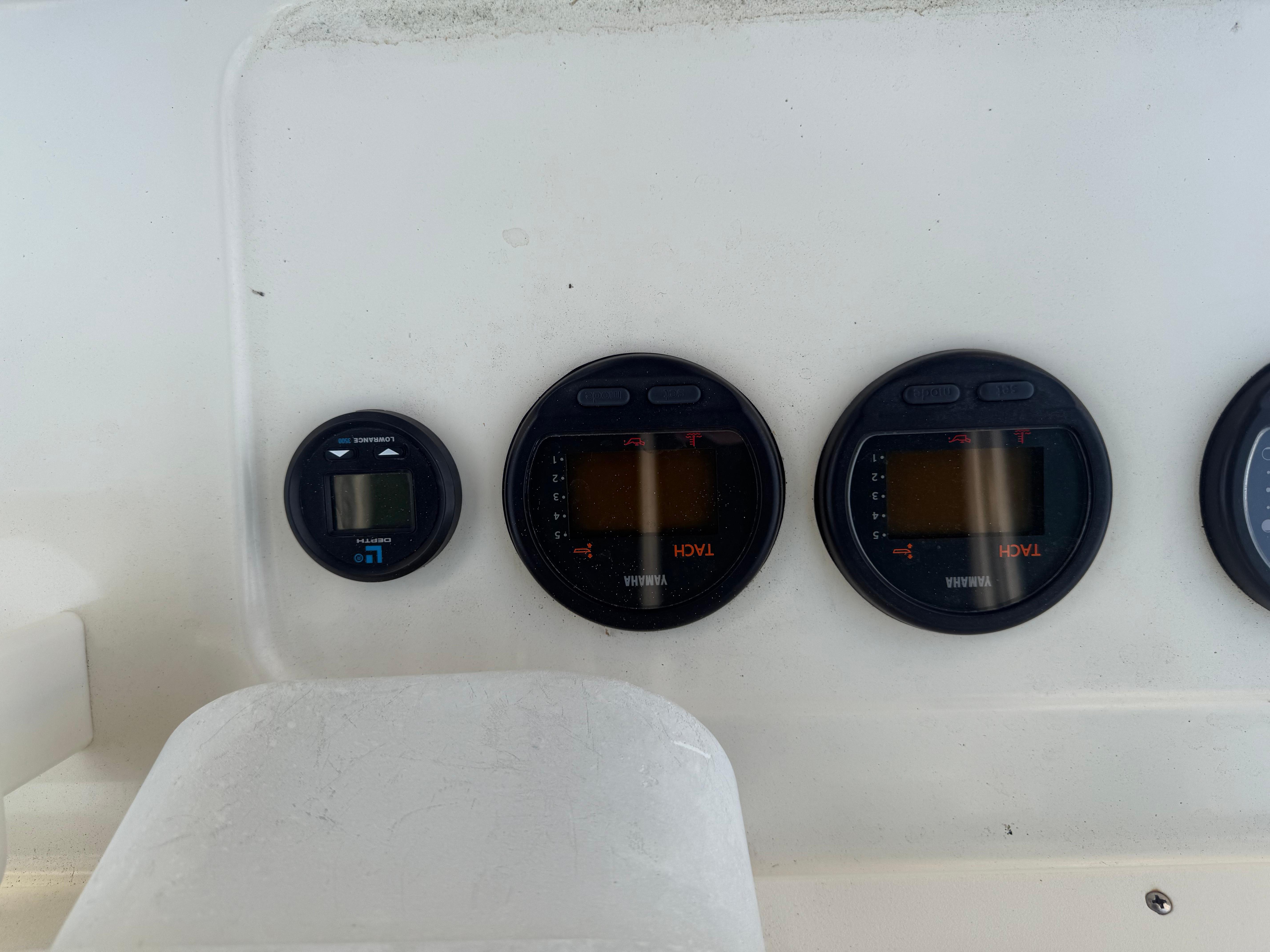 Dashboard gauges on a 2002 Pursuit 2470 CC boat, featuring Yamaha displays.