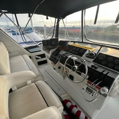 1991 Carver 33 Aft Cabin Motor Yacht cockpit with steering wheel and navigation instruments.