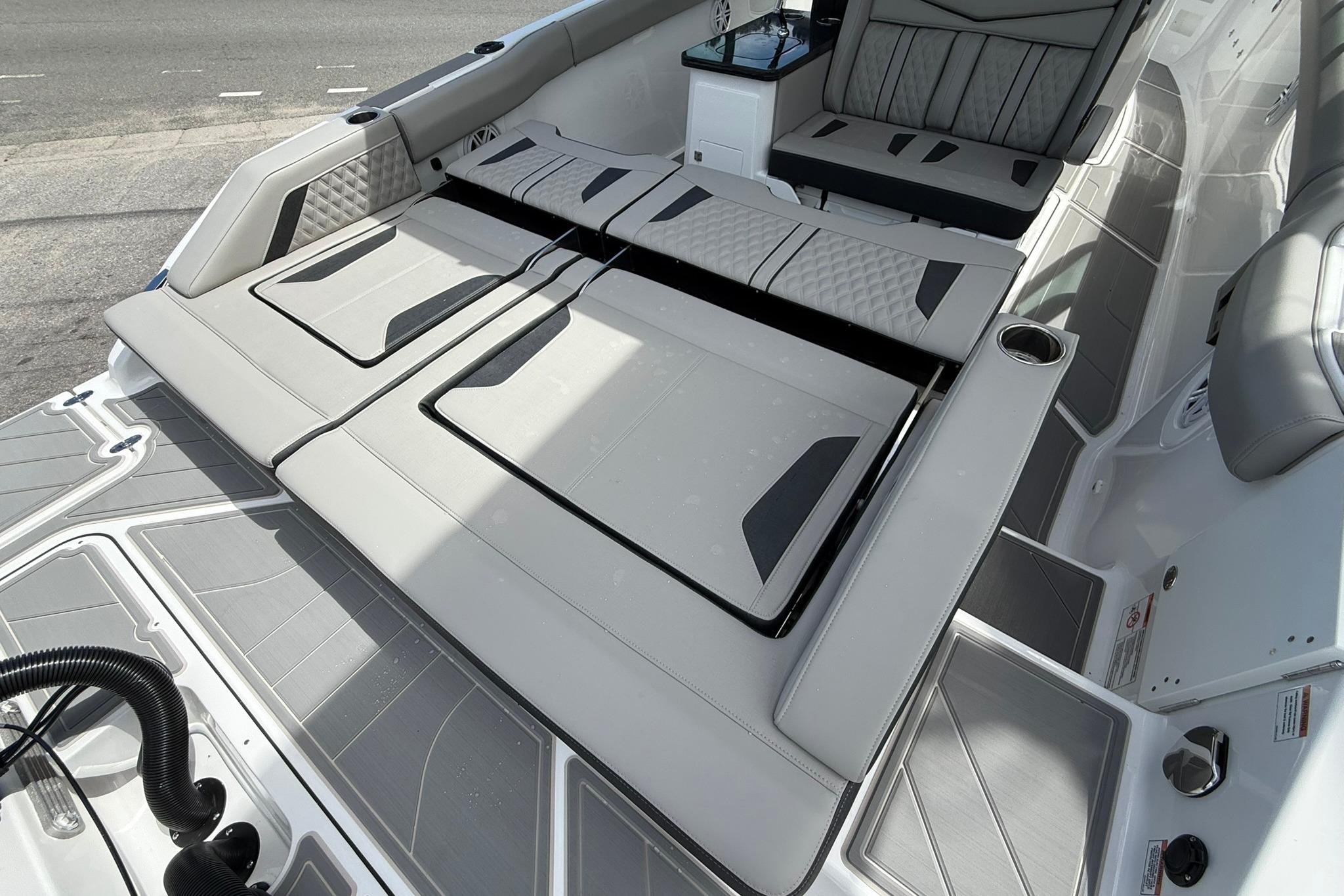 Luxurious seating area on a 2027 Monterey Elite 30 OB boat, featuring sleek, modern design.