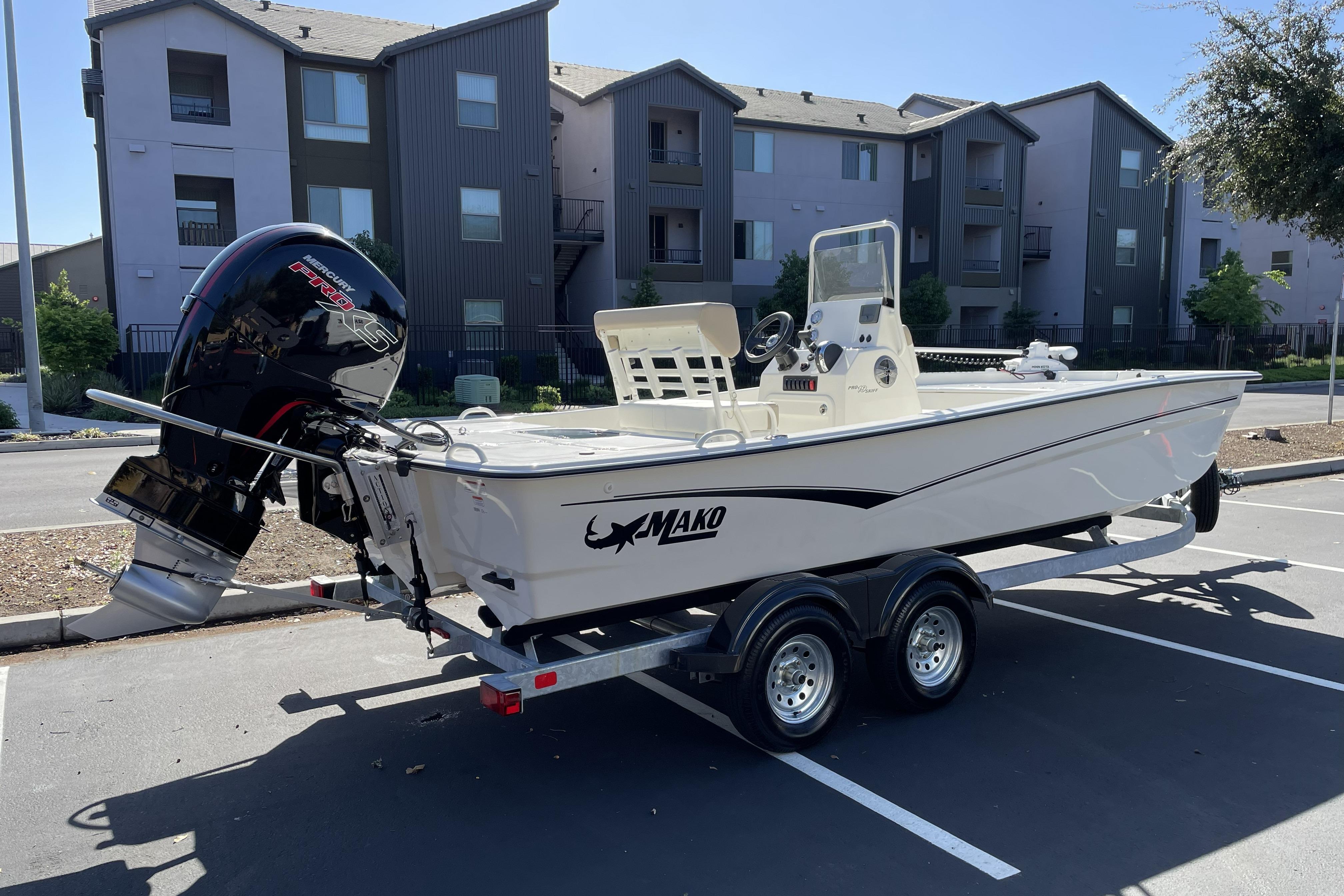 2026 Mako Pro Skiff 19 CC boat on trailer in parking lot.