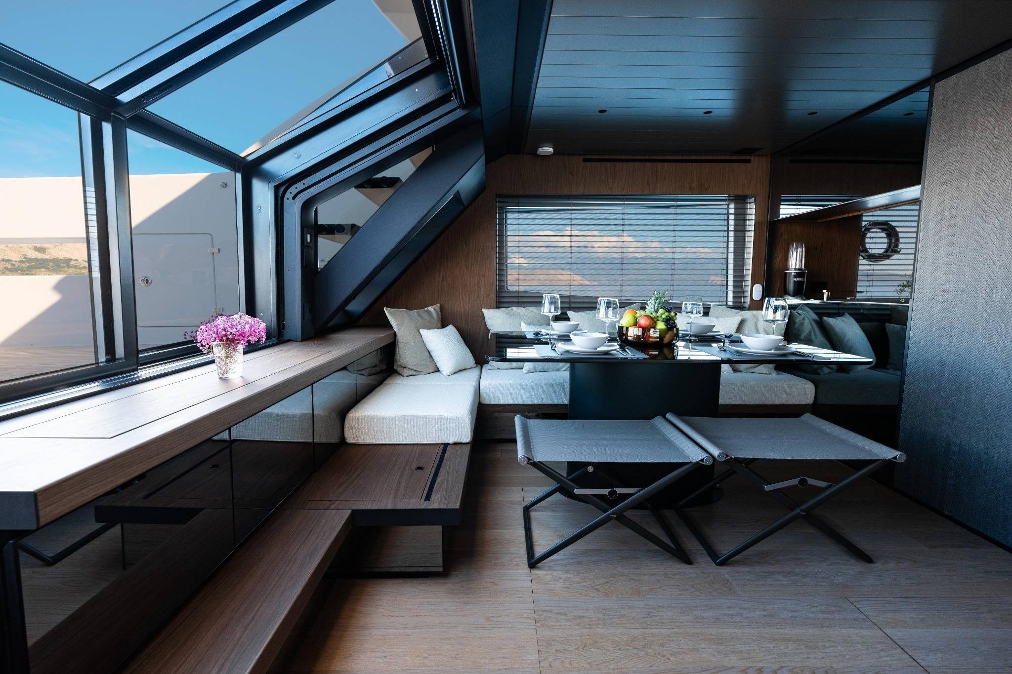 Luxurious interior of 2025 Bluegame BG74 yacht with elegant dining area and panoramic windows.