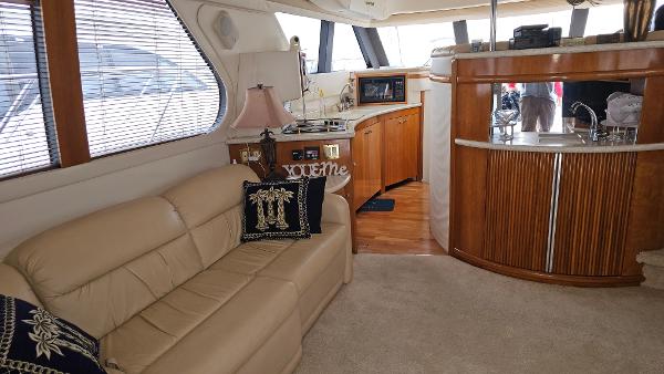 Interior of 2000 Carver 450 Voyager Pilothouse with beige sofa and wooden cabinetry.