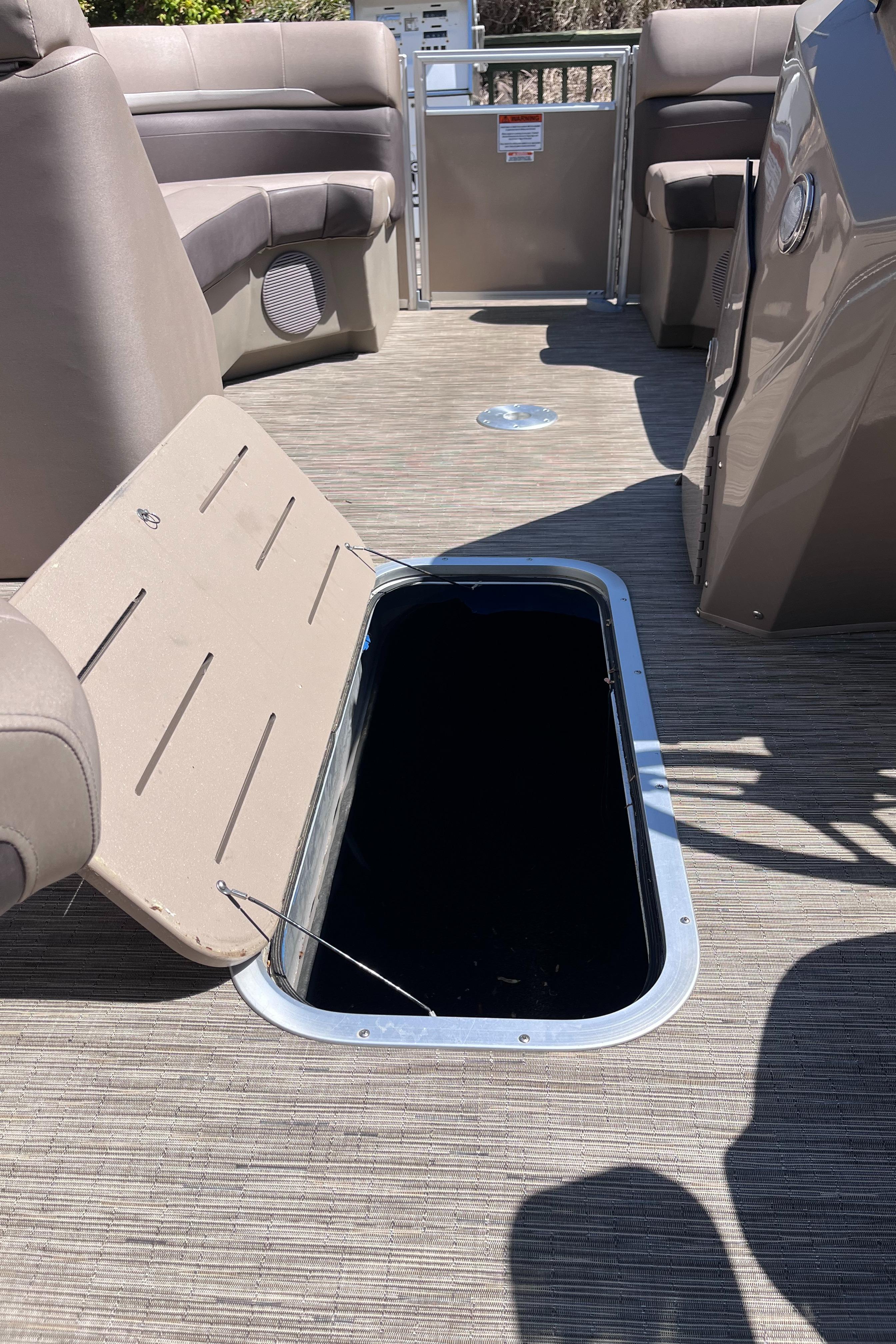 2023 Bennington 22 SXSR boat interior with open storage compartment.