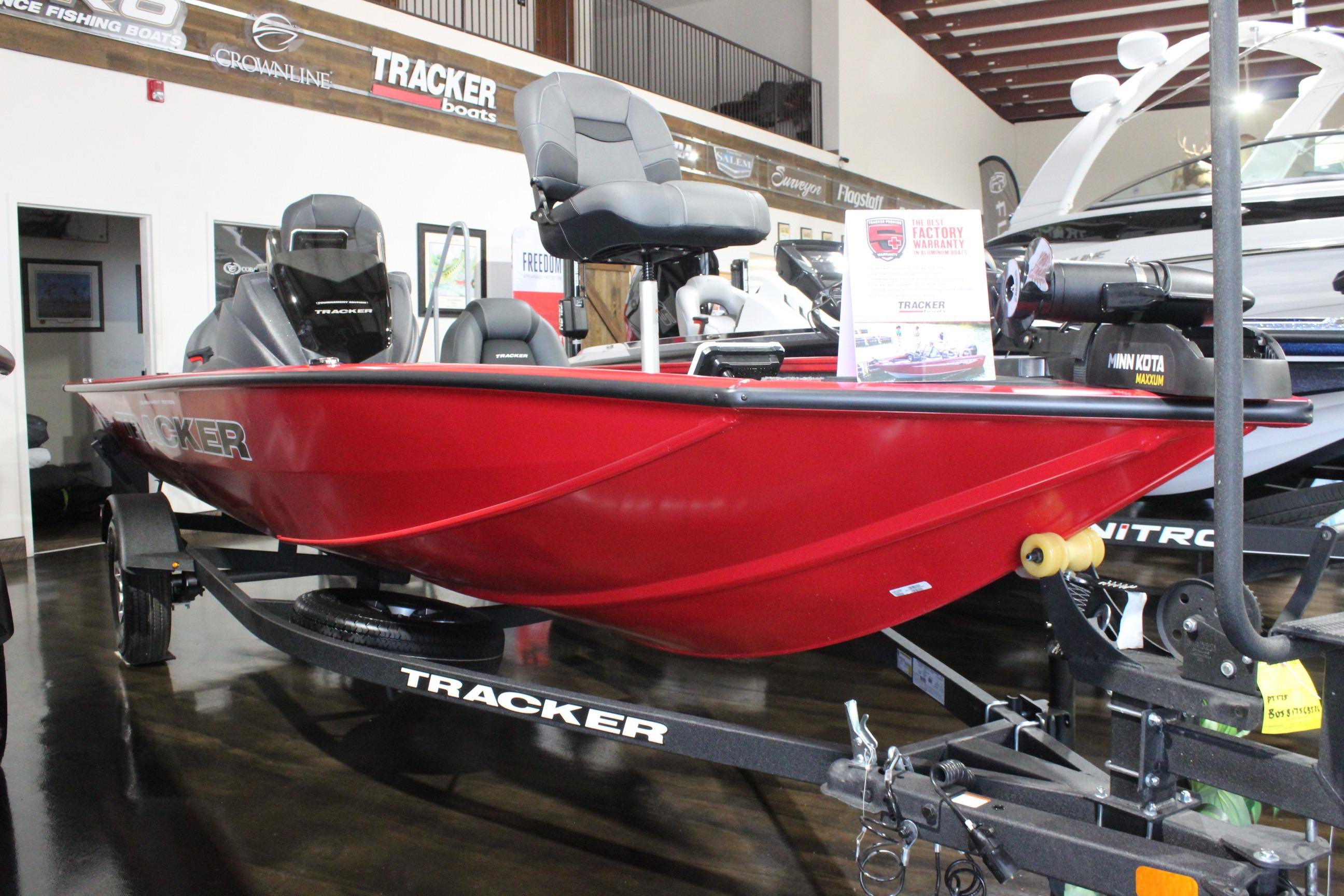 2026 Tracker Pro Team 175 boat in showroom, vibrant red color, on display.